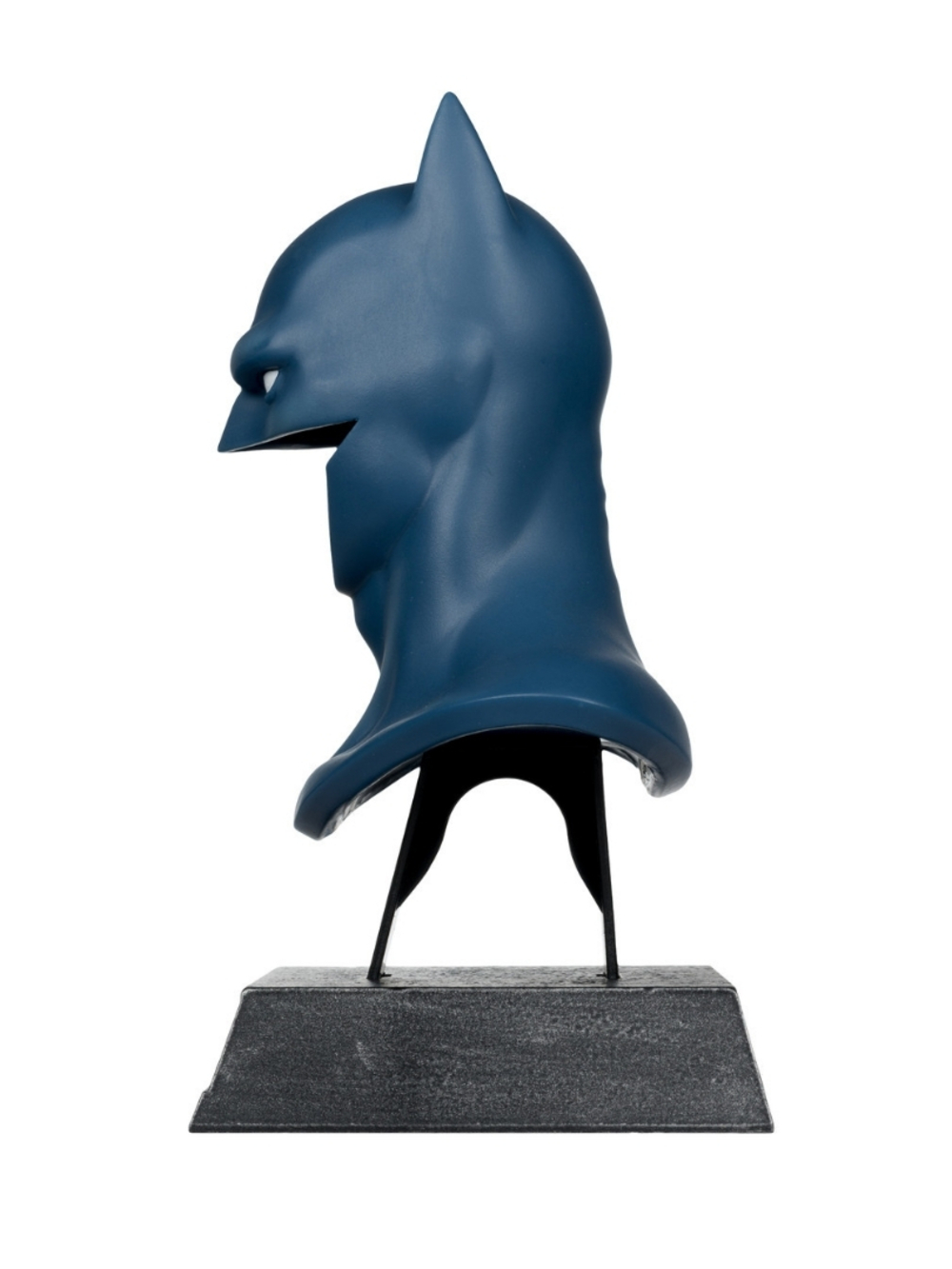 Mavi bir Batman büstü, profil görünümü. İki siyah destekle gri bir taban üzerinde duruyor. Arka plan düz beyaz.