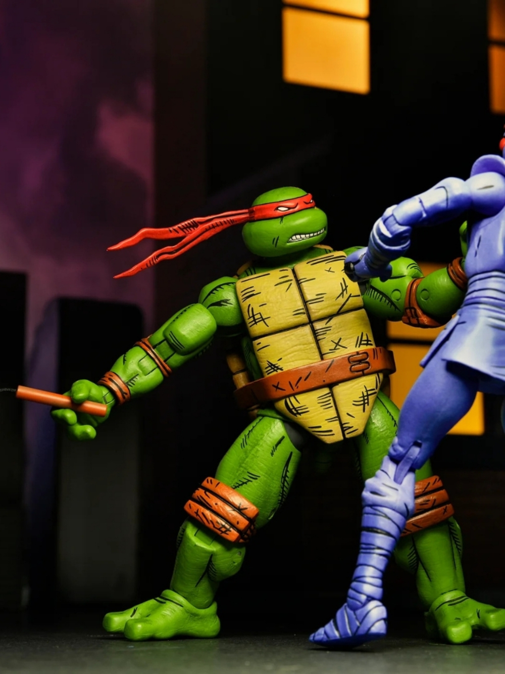 Kırmızı bandanalı bir Ninja Kaplumbağa, Raphael, nunchakular tutuyor. Mavi renkli başka bir figür dövüşüyor.