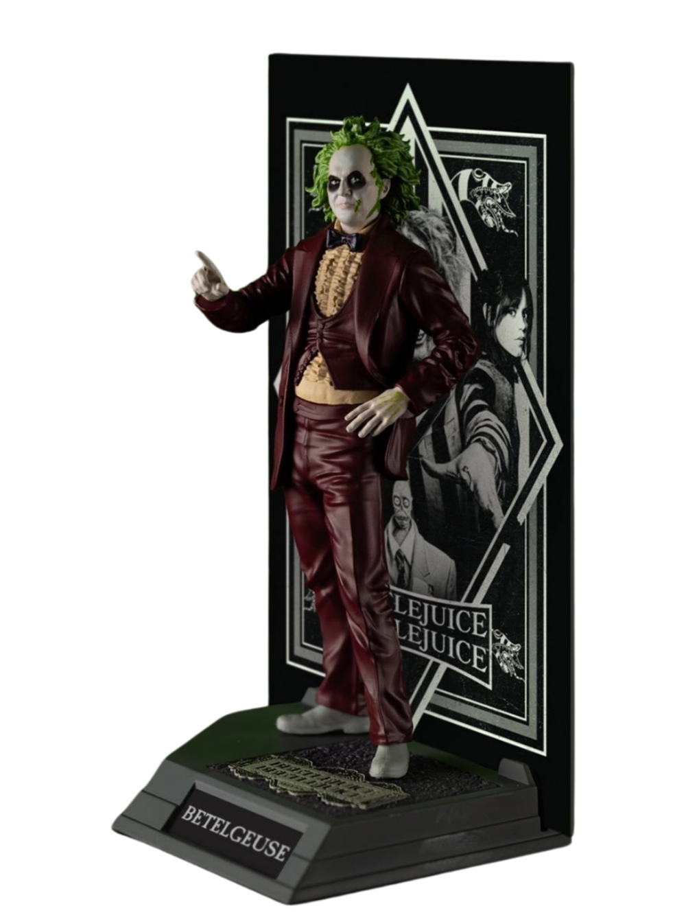 Bordo takım elbiseli, yeşil saçlı ve soluk tenli Beetlejuice figürü. Arkasında bir film afişi olan bir taban üzerinde duruyor.
