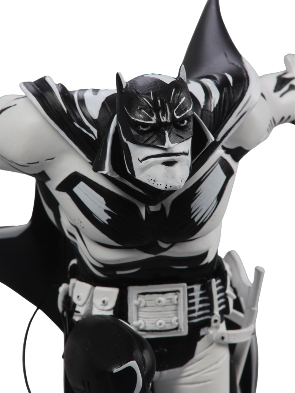 Siyah beyaz bir Batman heykeli. Siyah bir başlık ve pelerin giyiyor. Göğsü ve kolları siyah detaylarla beyazdır.