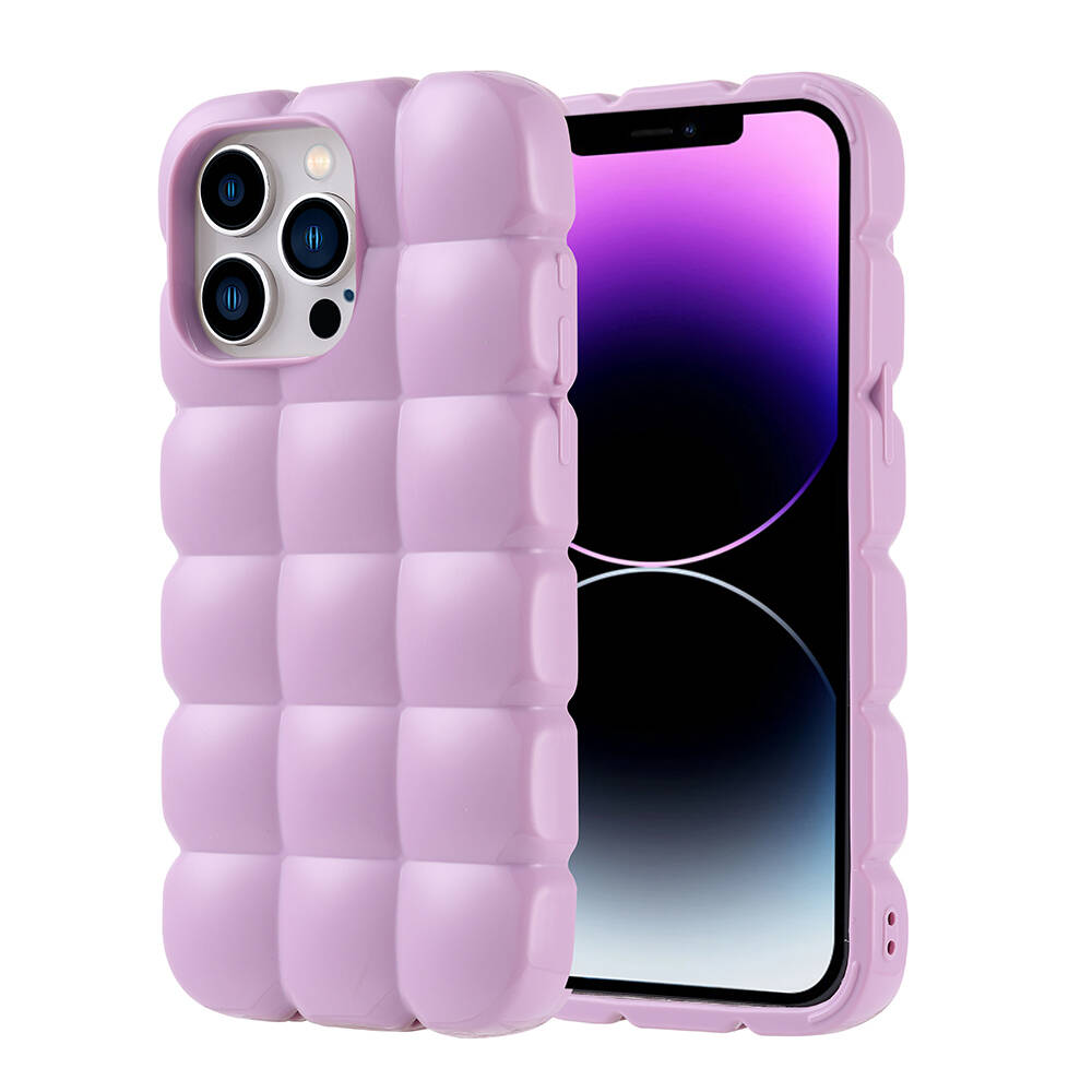 Mor renkli, kapitone tasarımlı bir telefon kılıfı, mor ve siyah ekranlı bir iPhone'un yanında. Kılıfta kamera delikleri var.
