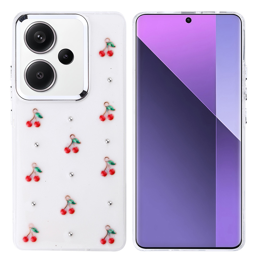 Beyaz arka planlı, kırmızı kiraz tılsımları ve gümüş çivilerle süslenmiş bir telefon kılıfı, yanında mor ekranlı bir telefon.