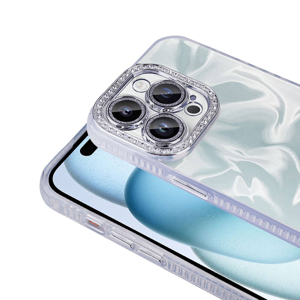 Dekoratif kamera lens kapağına sahip bir telefon kılıfı. Kapak, kamera lenslerinin etrafında elmas benzeri bir kenarlığa sahiptir. Telefon şeffaftır.