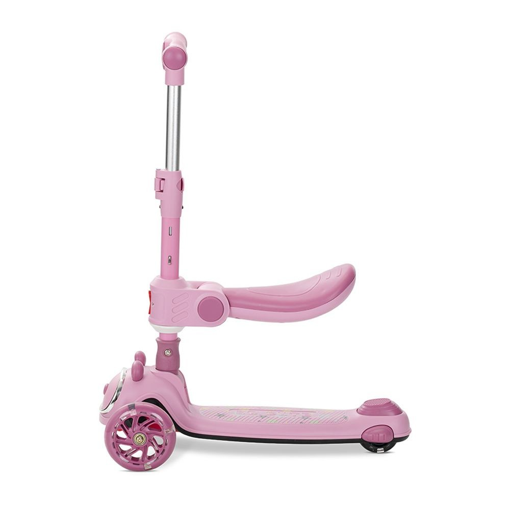 Patín rosa con asiento y manillar ajustable. Tres ruedas, adecuado para un niño. Aislado sobre fondo blanco.
