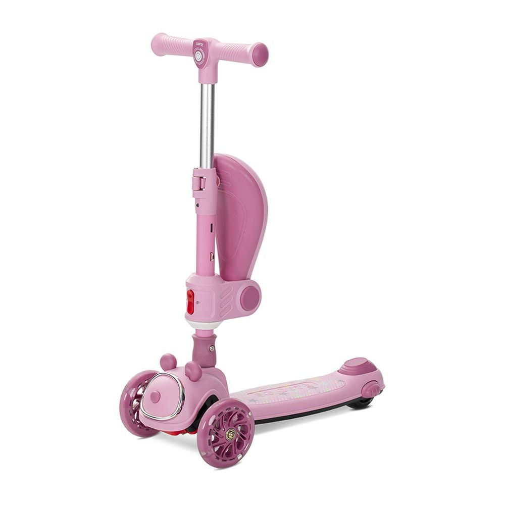 Un patinete rosa de tres ruedas, con asiento y manillar ajustable, aislado sobre fondo blanco.