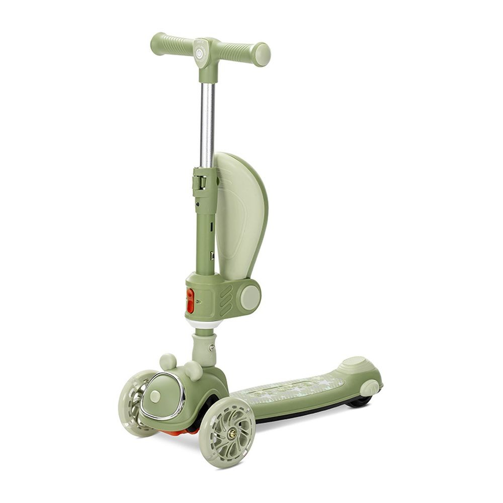Un patinete verde y blanco con tres ruedas, un asiento y un manillar. Está aislado sobre un fondo blanco.