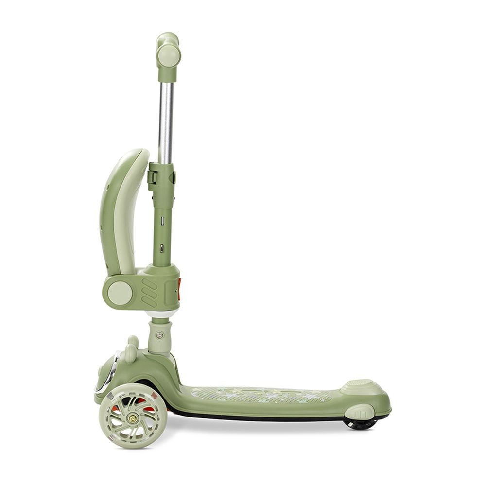 Un patinete verde con tres ruedas. El manillar es plateado. El patinete está sobre un fondo blanco.