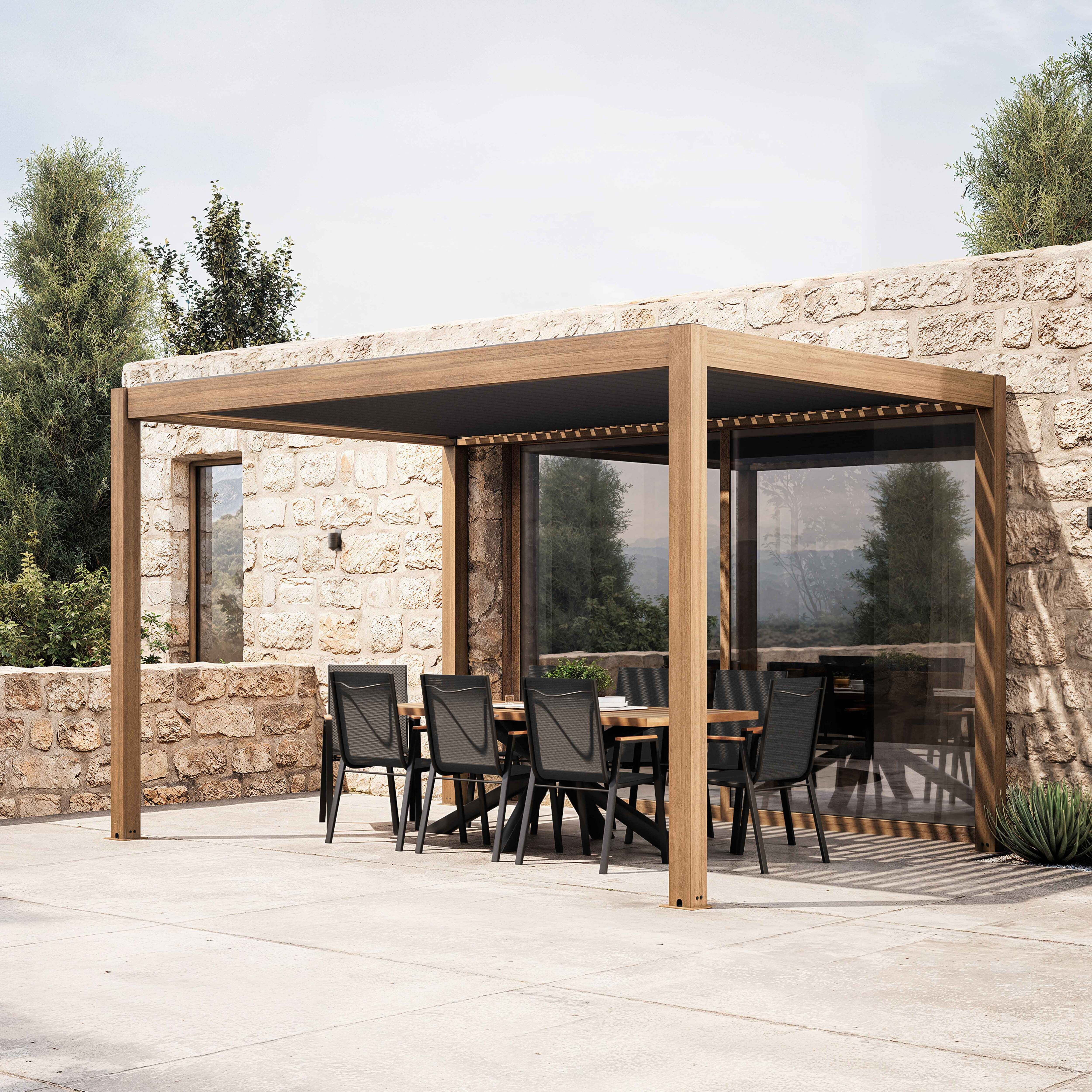 Essbereich im Freien mit Holzpergola, Tisch und Stühlen. Steinmauer im Hintergrund, Bäume und Pflanzen.