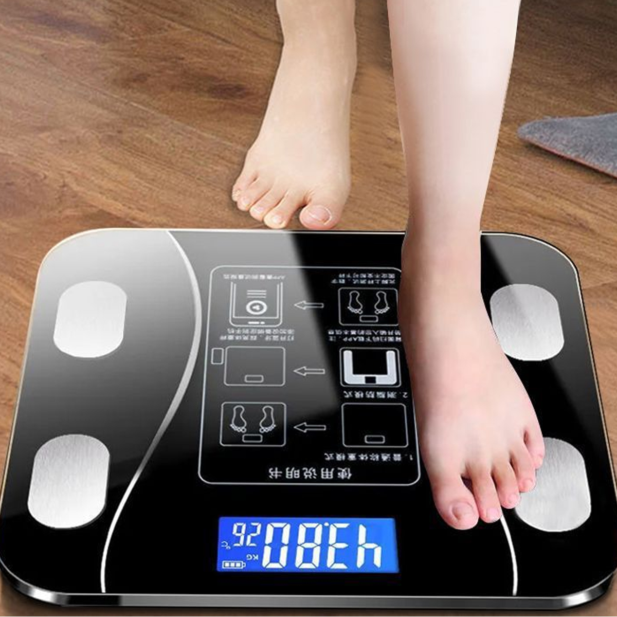 Eine Person steht auf einer schwarzen Digitalwaage. Die Waage zeigt ein Gewicht von 43,80 kg an. Ein Fuß ist auf der Waage, der andere nicht.