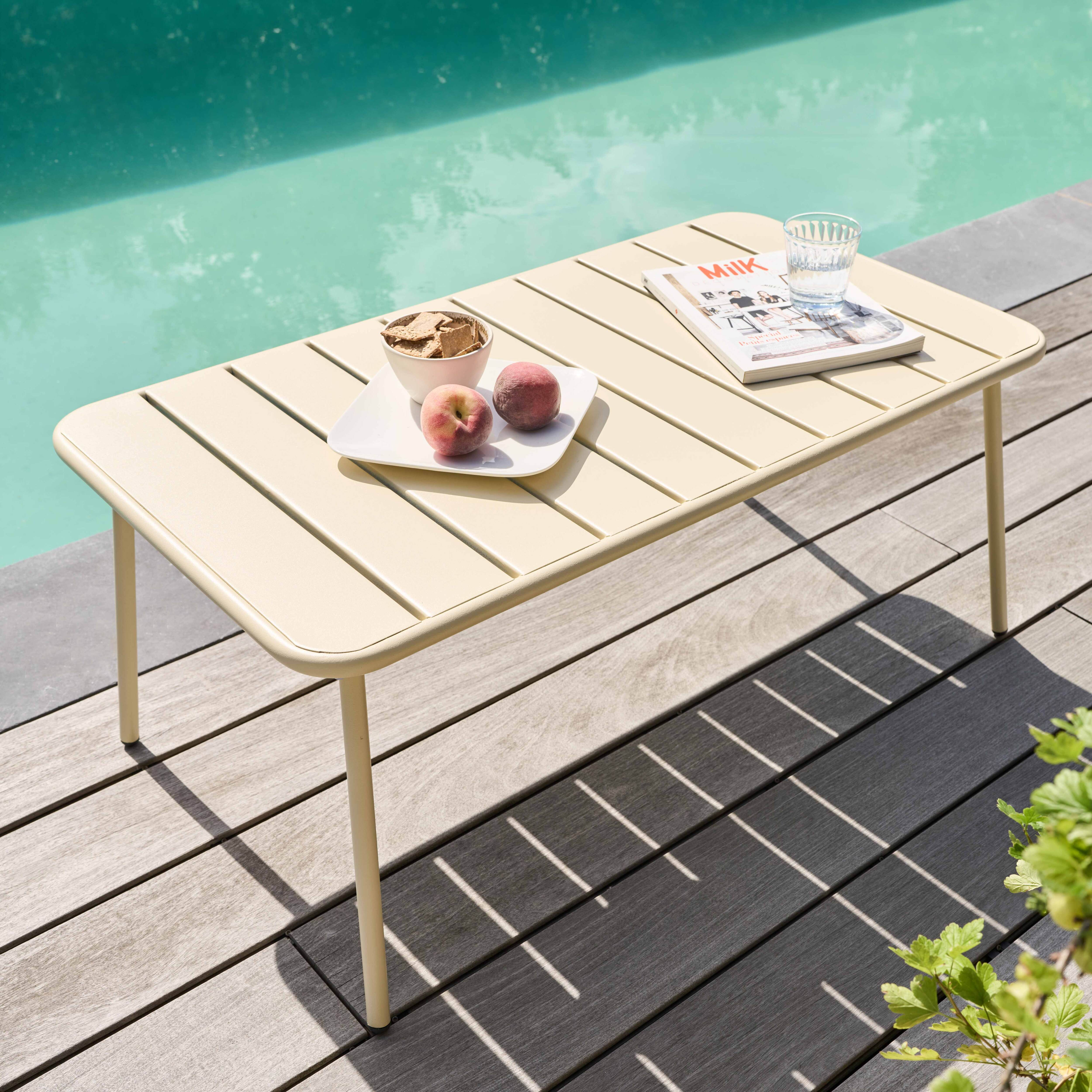 Ein cremefarbener Tisch mit Snacks und einer Zeitschrift steht am Pool. Pfirsiche, Cracker und ein Glas Wasser sind darauf.