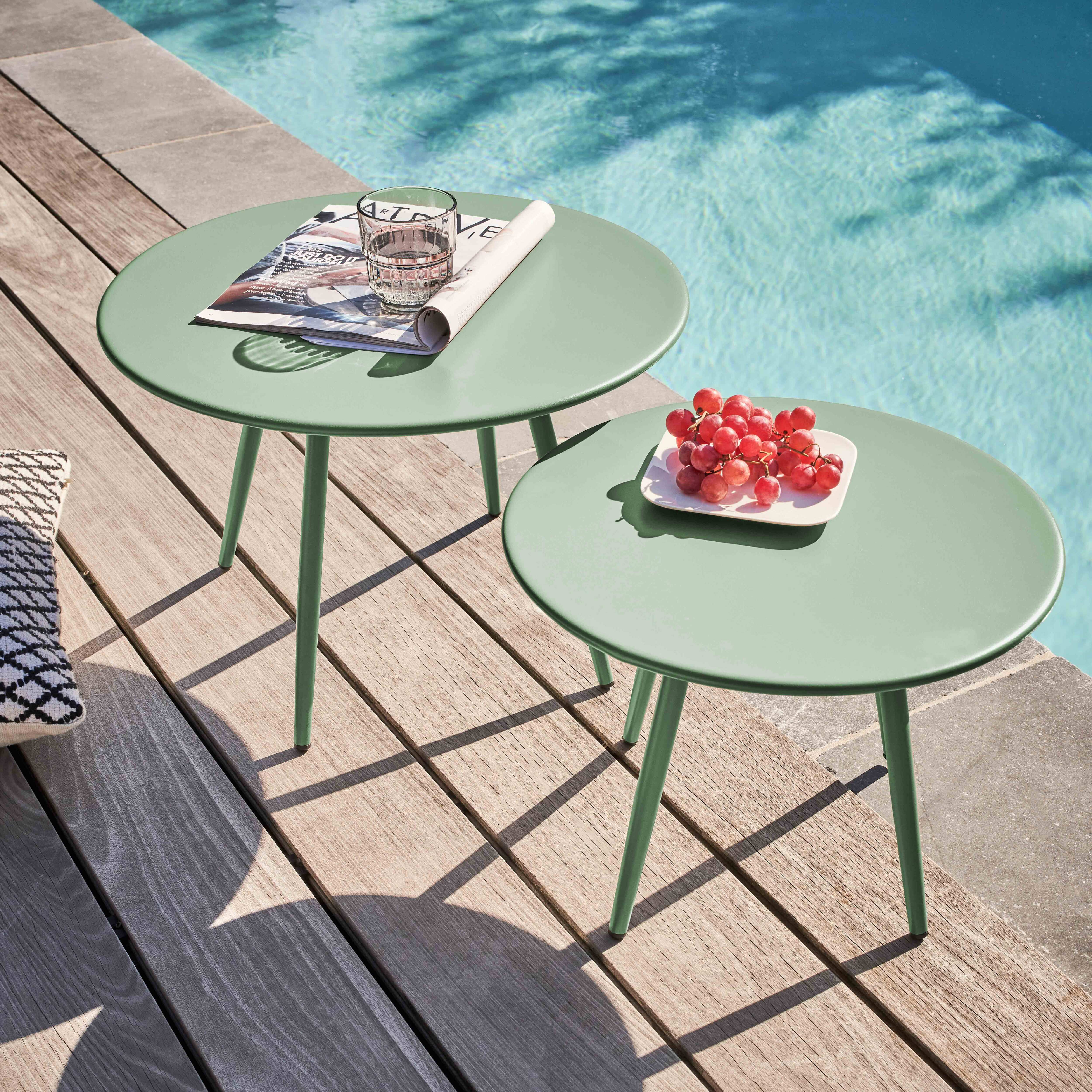 Zwei grüne Tische mit einem Glas Wasser und Trauben stehen am Pool. Ein Holzdeck umgibt den Pool.