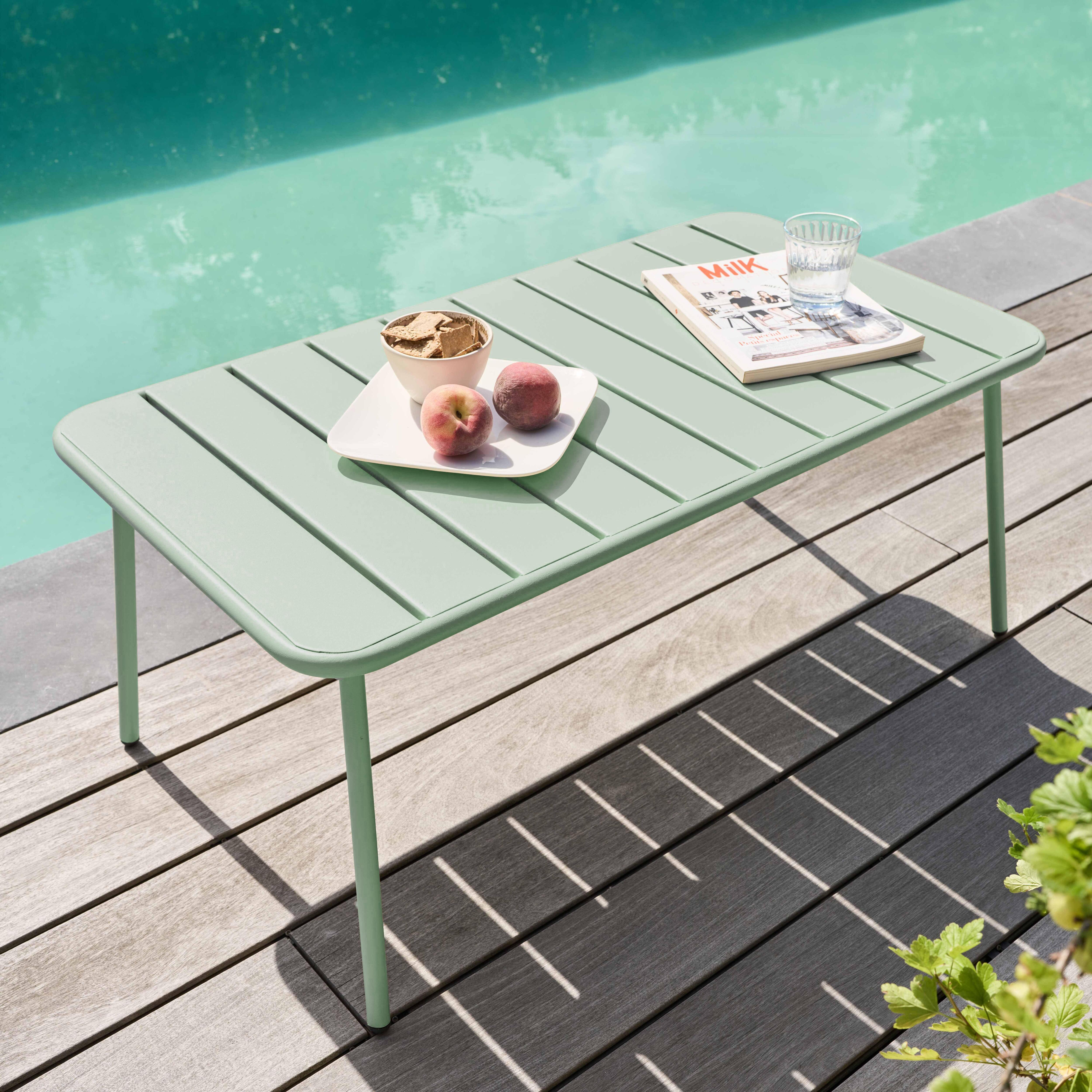 Ein mintfarbener Tisch mit Snacks, Pfirsichen und einer Zeitschrift steht am Pool. Holzdeck und grünes Laub im Hintergrund.