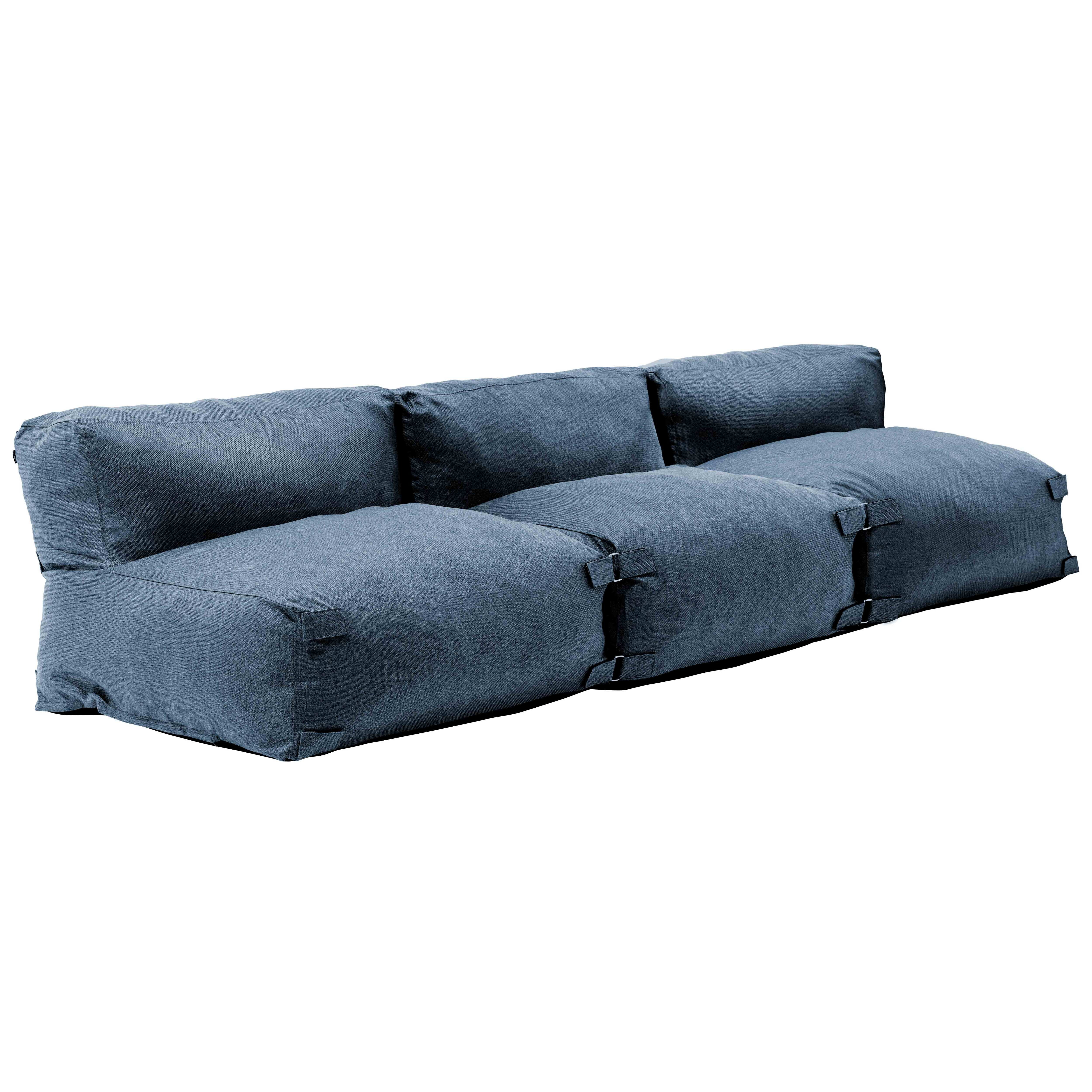 Ein blaues modulares Stoffsofa vor weißem Hintergrund. Es besteht aus drei verbundenen Abschnitten mit Kissen.