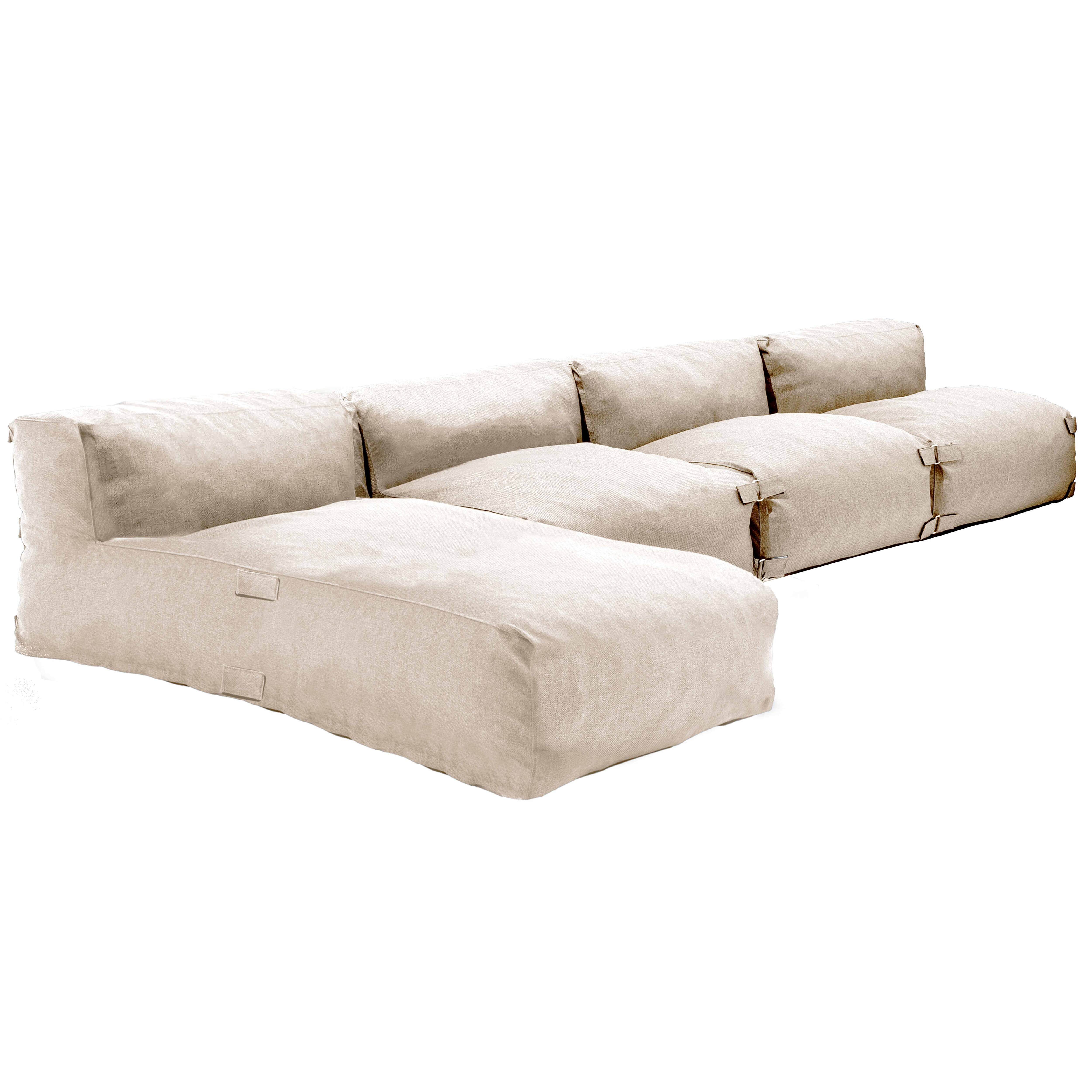 Beiges Modulsofa vor weißem Hintergrund. Es hat mehrere Abschnitte und eine Chaiselongue.