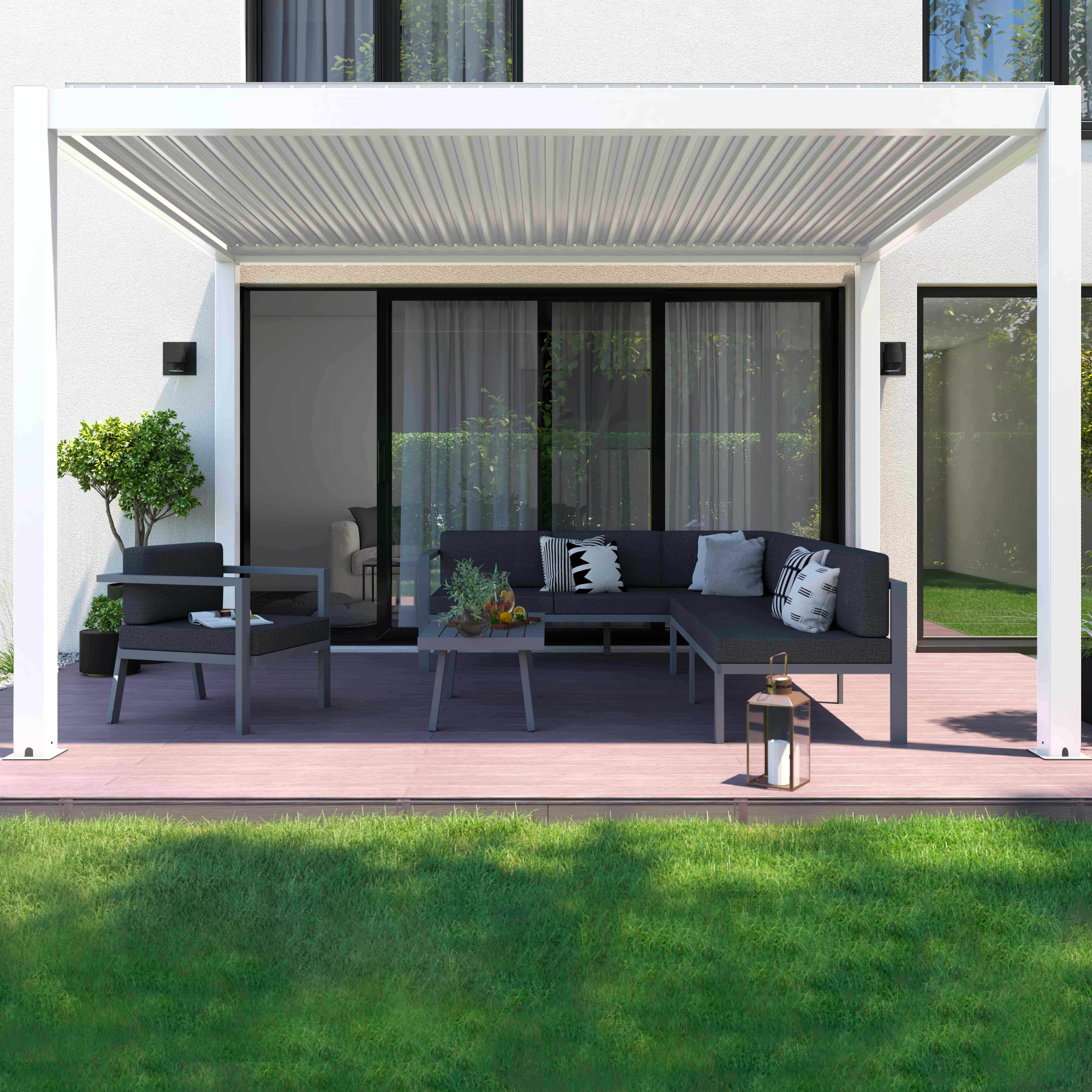 Eine moderne Terrasse mit grauen Möbeln unter einer weißen Pergola. Grüner Rasen im Vordergrund und ein weißes Gebäude im Hintergrund.