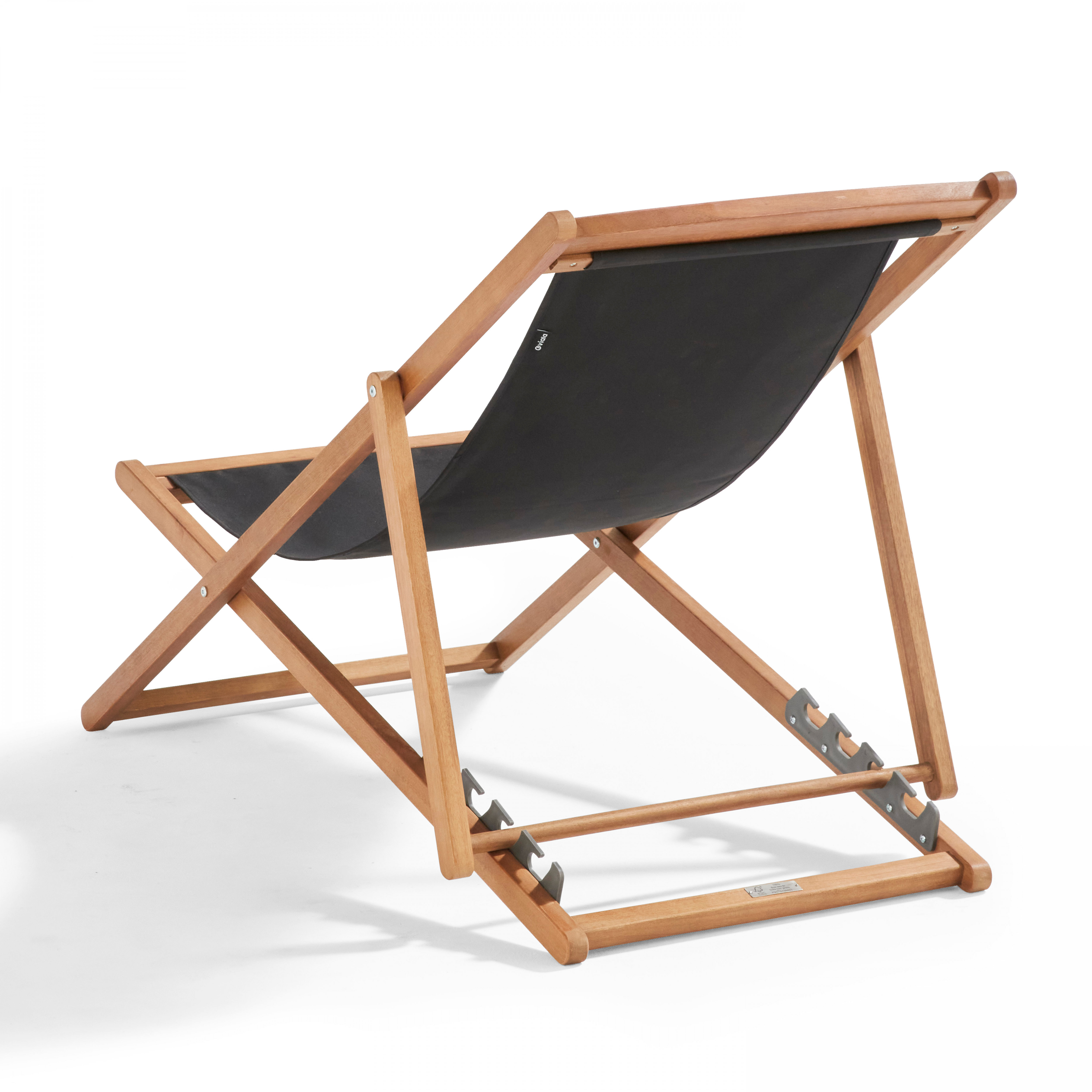 Ein hölzerner Deckchair mit schwarzem Stoffbezug vor weißem Hintergrund. Der Stuhl ist leicht angewinkelt.