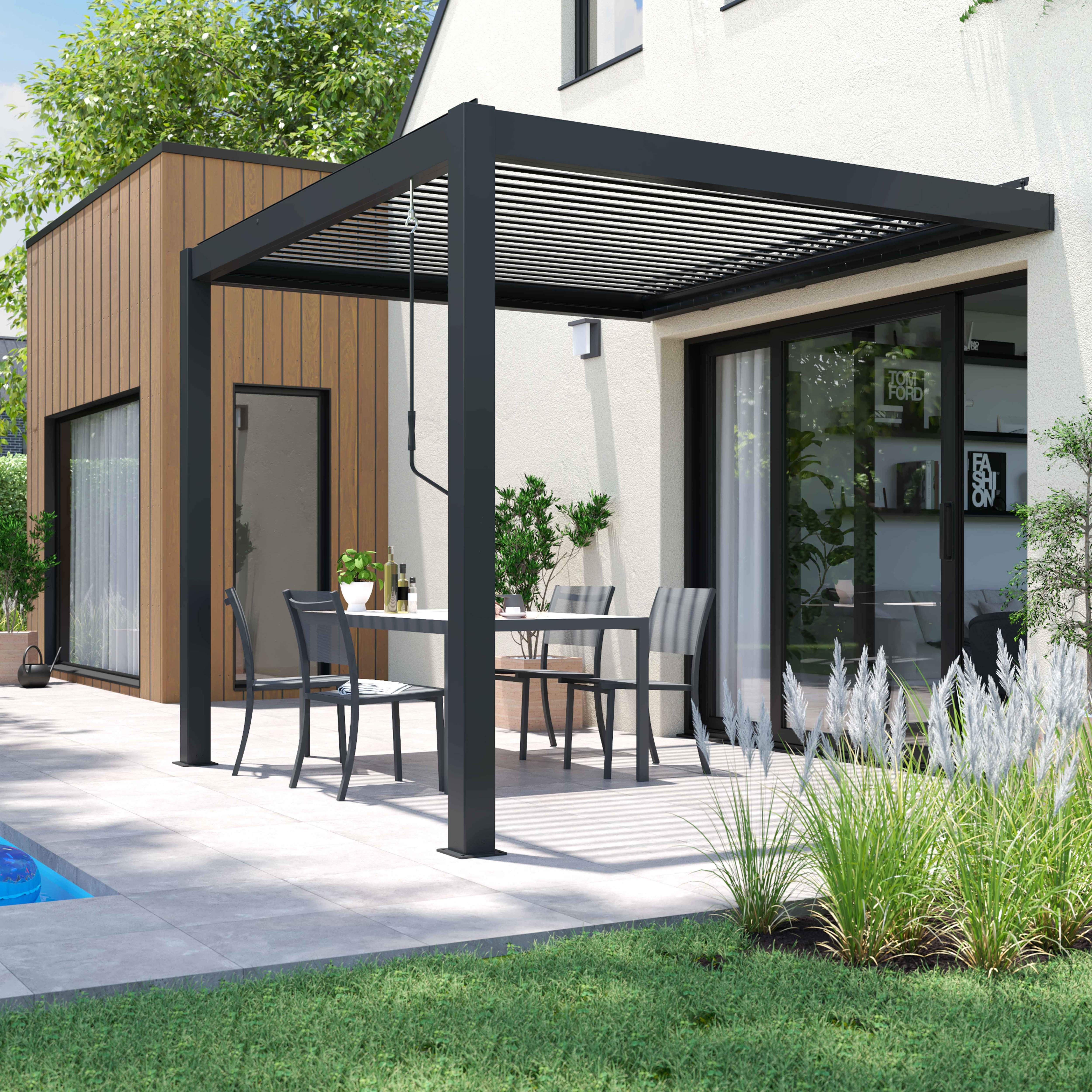 Eine Terrasse mit einer schwarzen Pergola, Tisch und Stühlen. Eine Holzwand und ein weißes Haus im Hintergrund.