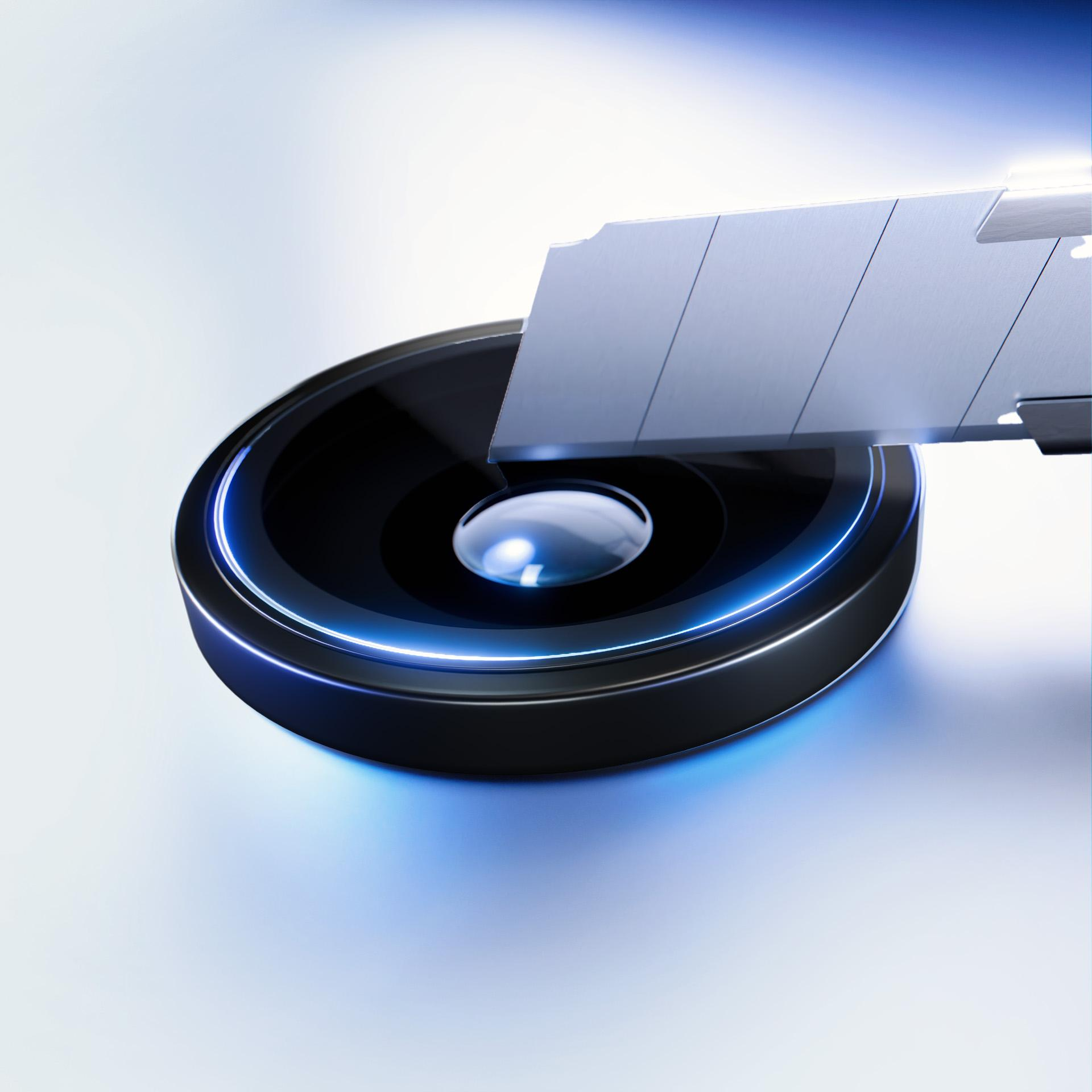 Czarny okrągły obiekt ze srebrnym ostrzem na wierzchu, otoczony niebieskim światłem.