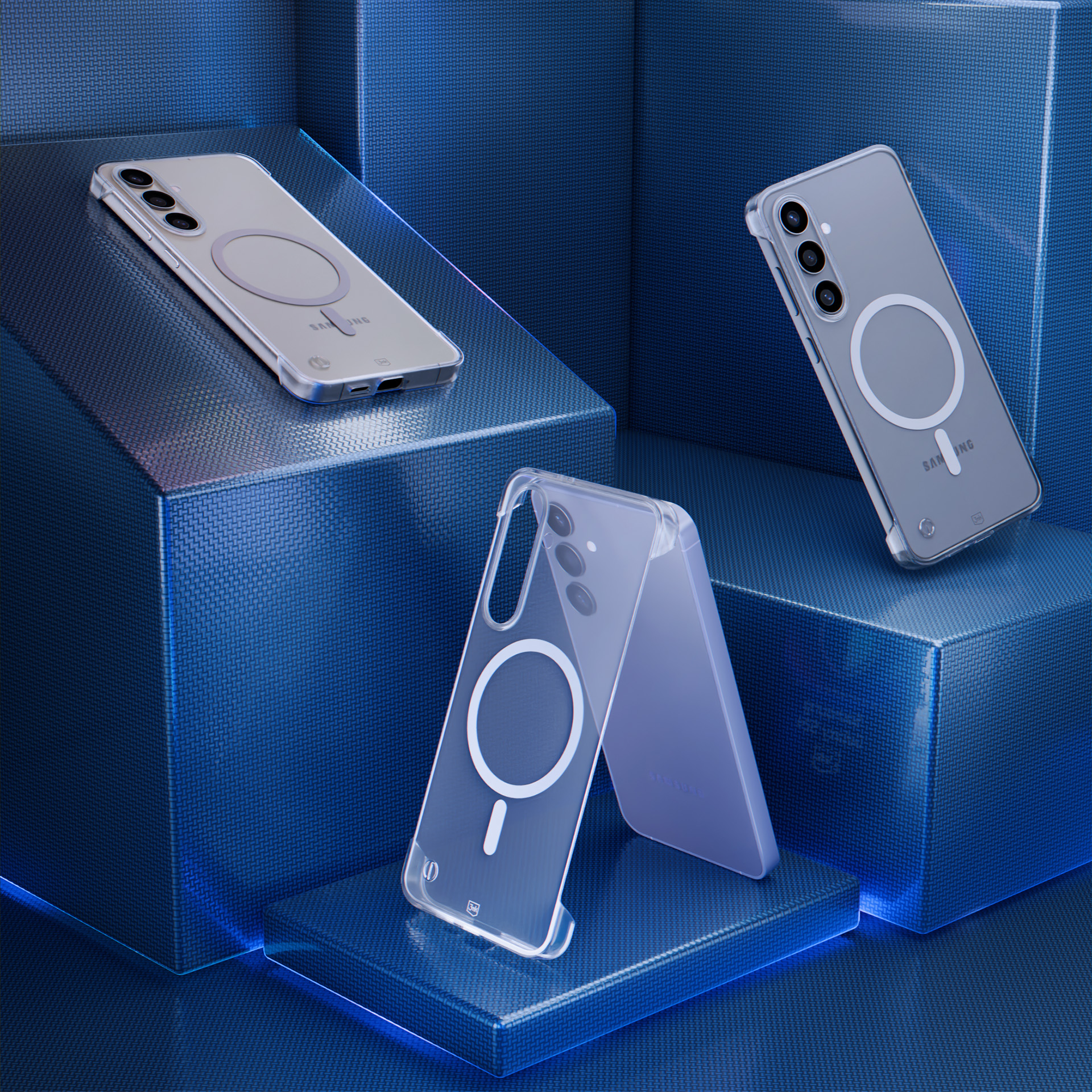 Trzy przezroczyste etui na telefony z MagSafe na niebieskich geometrycznych blokach. Etui pokazują aparaty telefonu i logo Samsung.