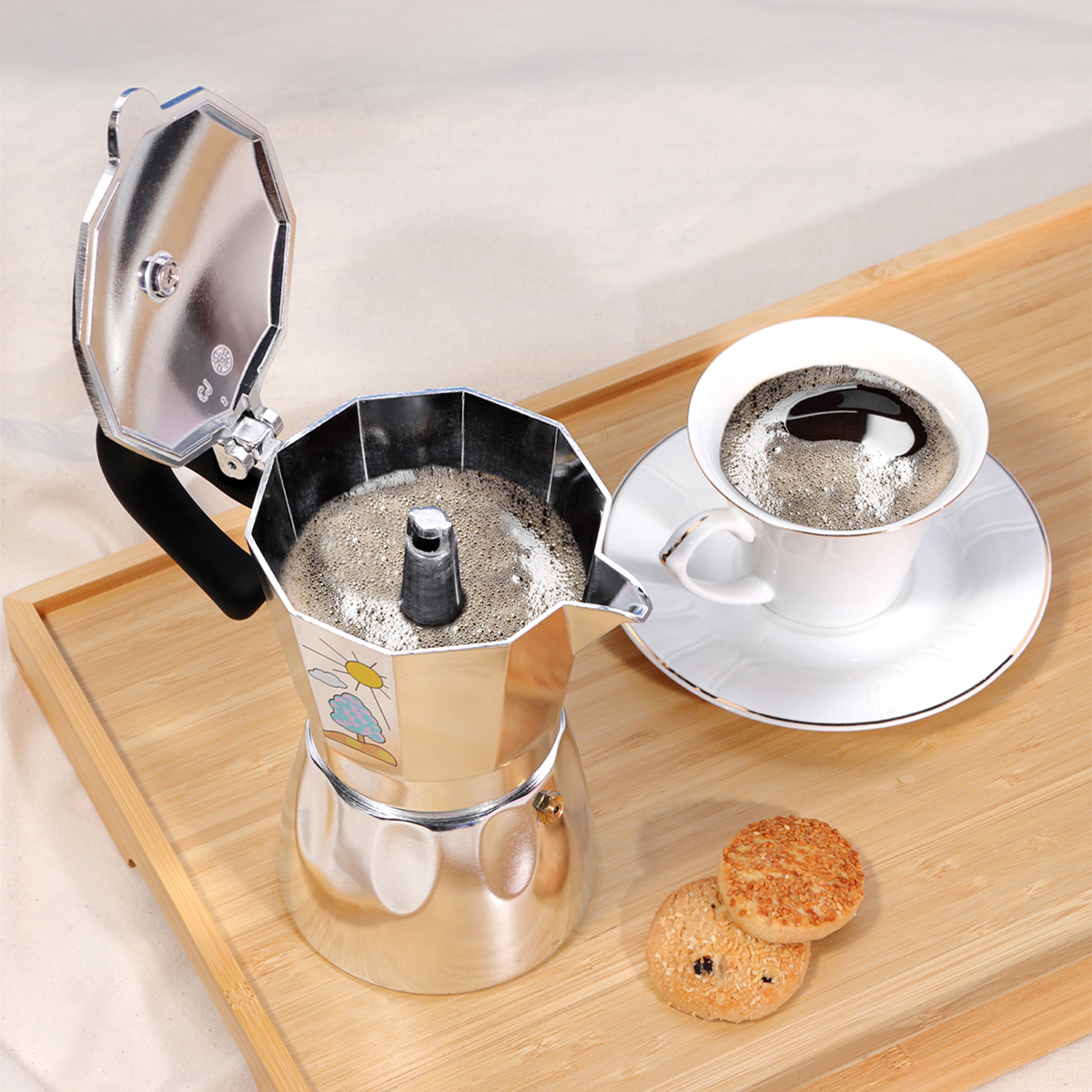 Eine Kaffeekanne, eine Kaffeetasse und Kekse stehen auf einem Holztablett. Der Topf ist offen, die Tasse ist voll Kaffee und die Kekse sind rund.