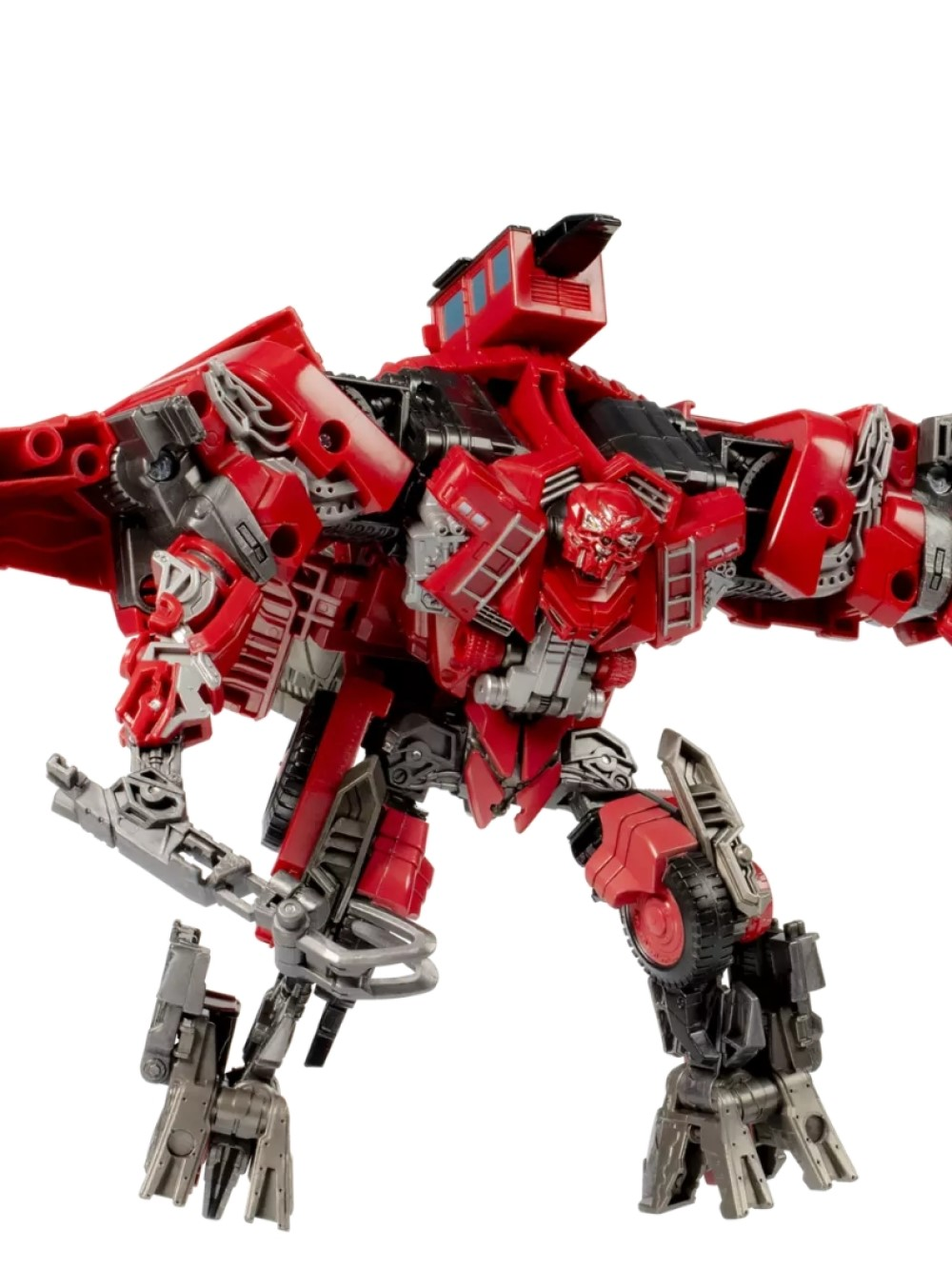 Kırmızı ve gri bir Transformer oyuncağı gösteriliyor. Robot, bükülmüş kollar, açık bacaklar ve detaylı bir baş ile savaş pozisyonunda.