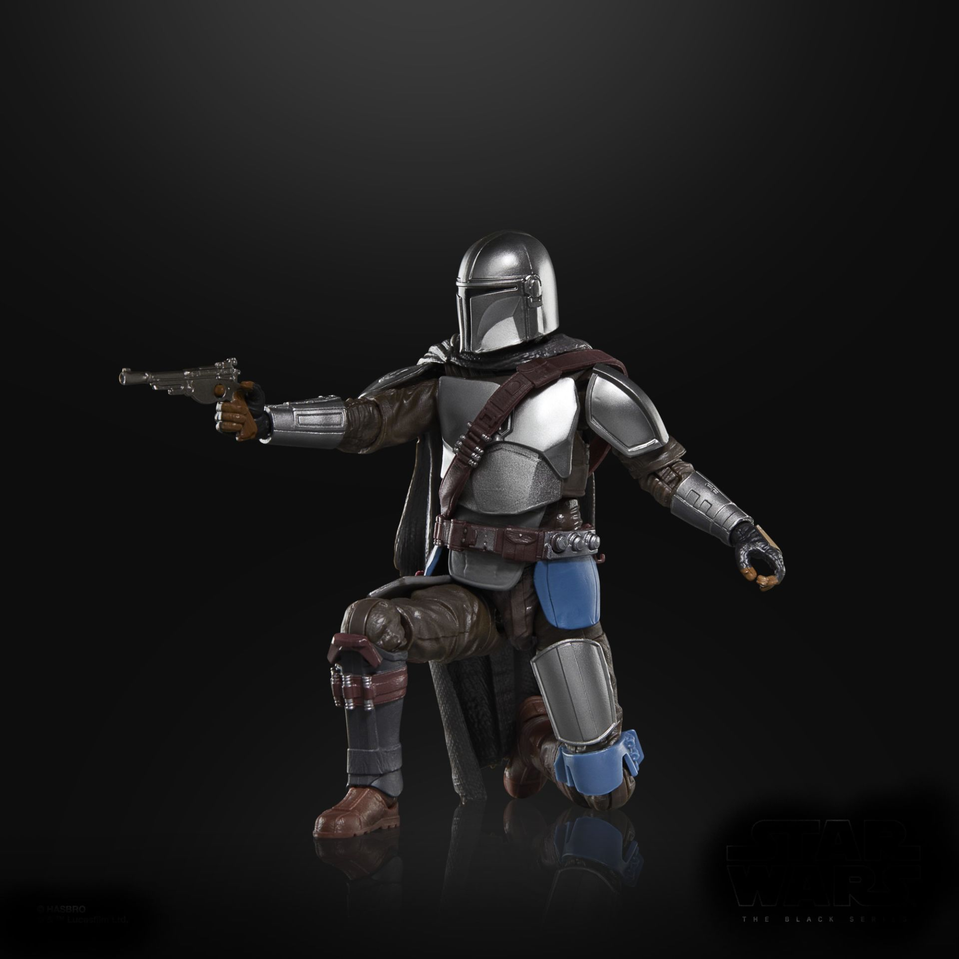 Mandalorian figürü diz çöküyor, elinde bir patlayıcı var. Gümüş zırh, kahverengi giysiler ve siyah bir pelerin siyah bir arka plan üzerinde.
