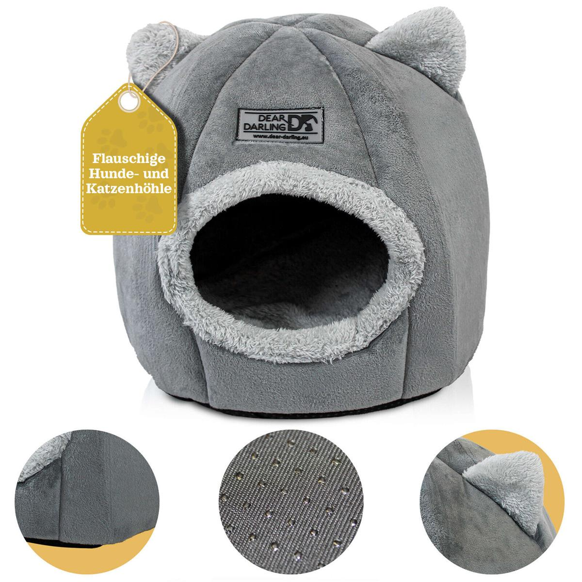 Ein graues Katzenbett mit rundem Eingang und ohrenförmigen Vorsprüngen. Ein gelbes Etikett liest: 'Flauschige Hunde- und Katzenhöhle'.