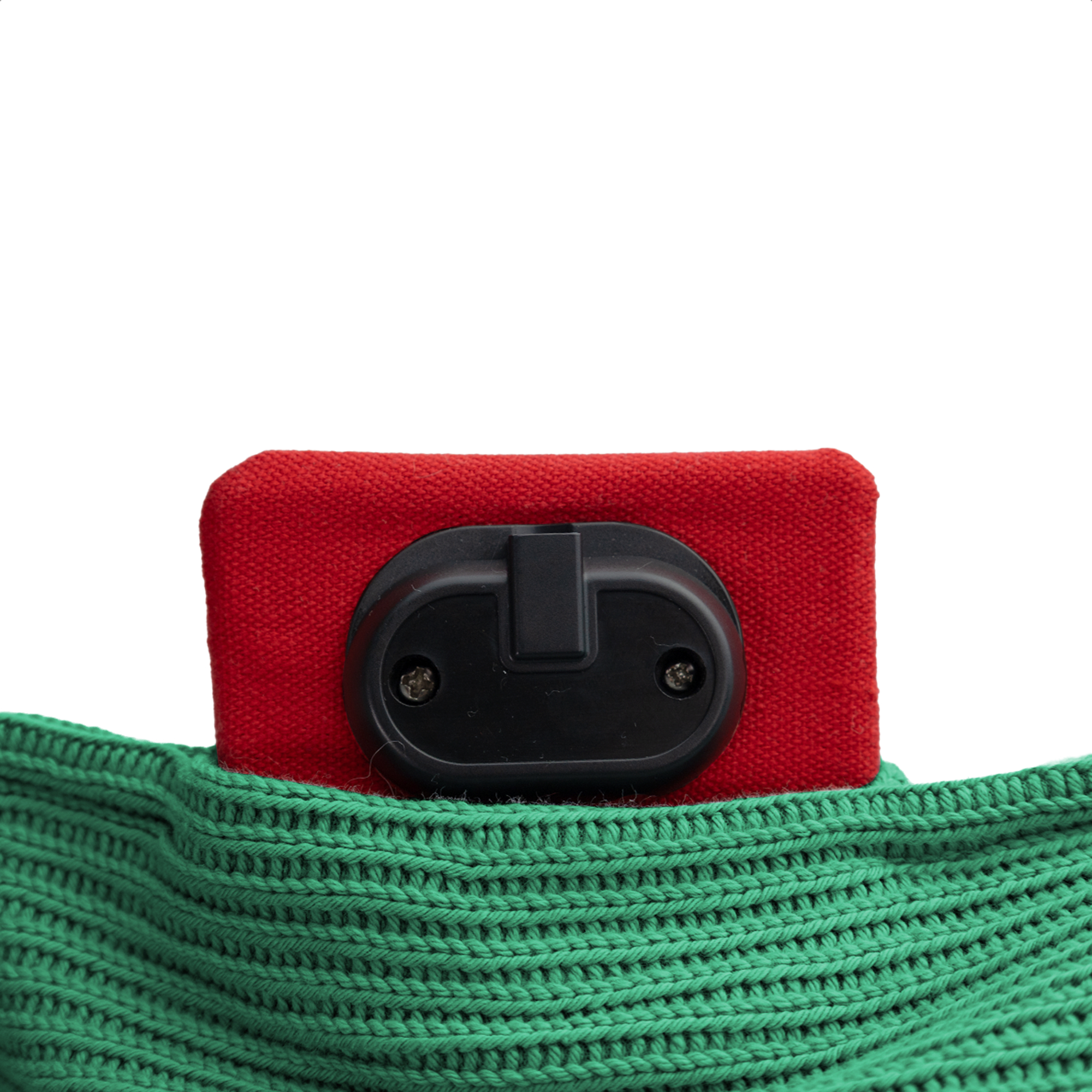 Un objet rouge avec un composant noir repose sur un tissu vert tricoté, le tout sur fond blanc.