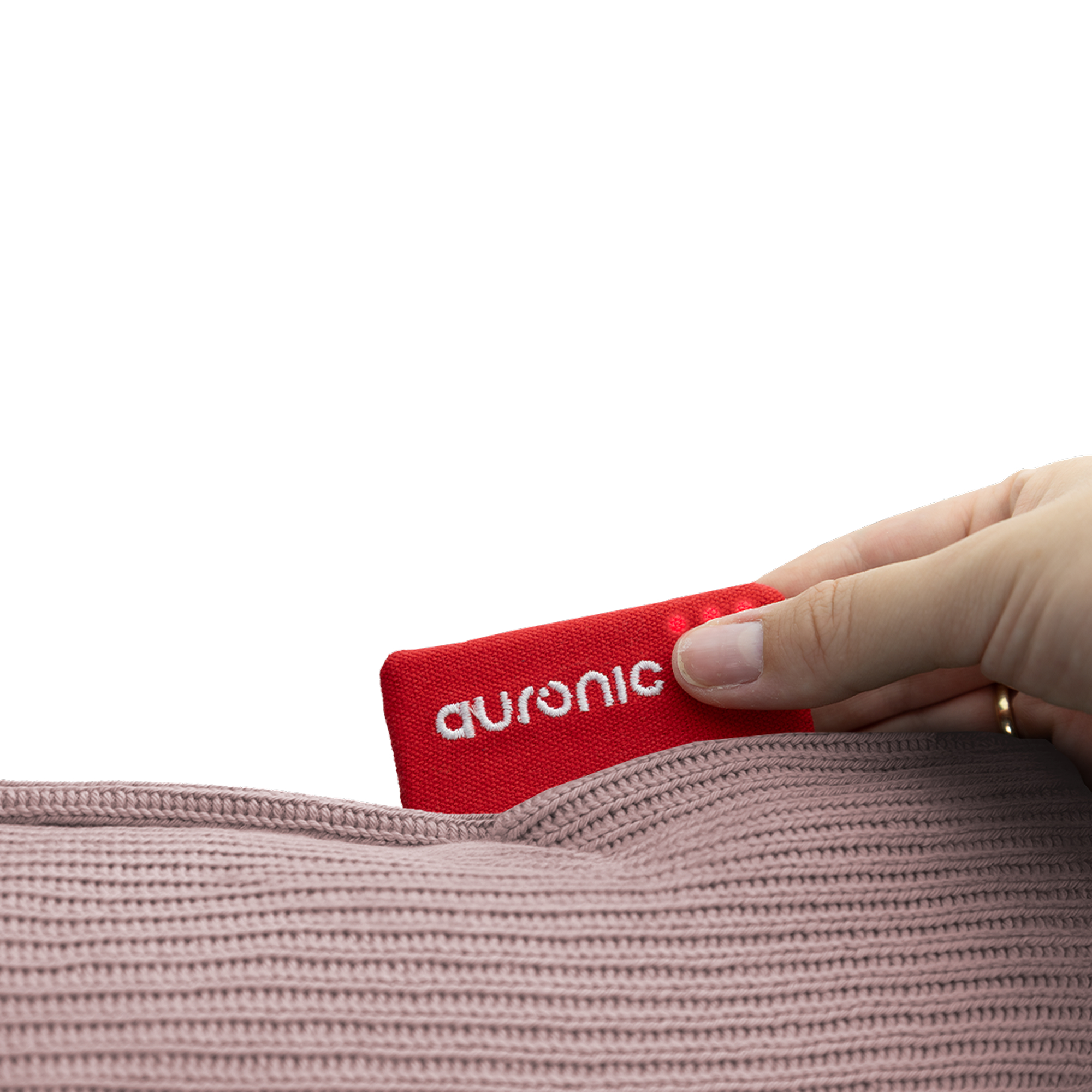 A hand pulls a red Auronic tag from a pink knitted fabric. The tag has white text.