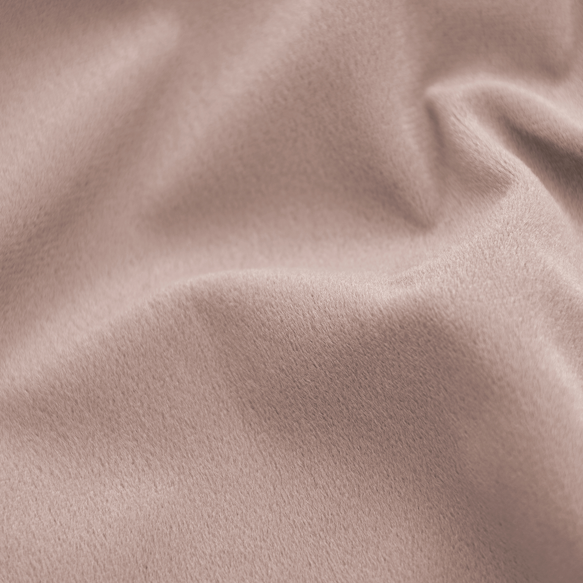 Close-up van een zachte, roze-bruine stof met een fluwelen textuur. De stof heeft zachte plooien en een subtiele glans.