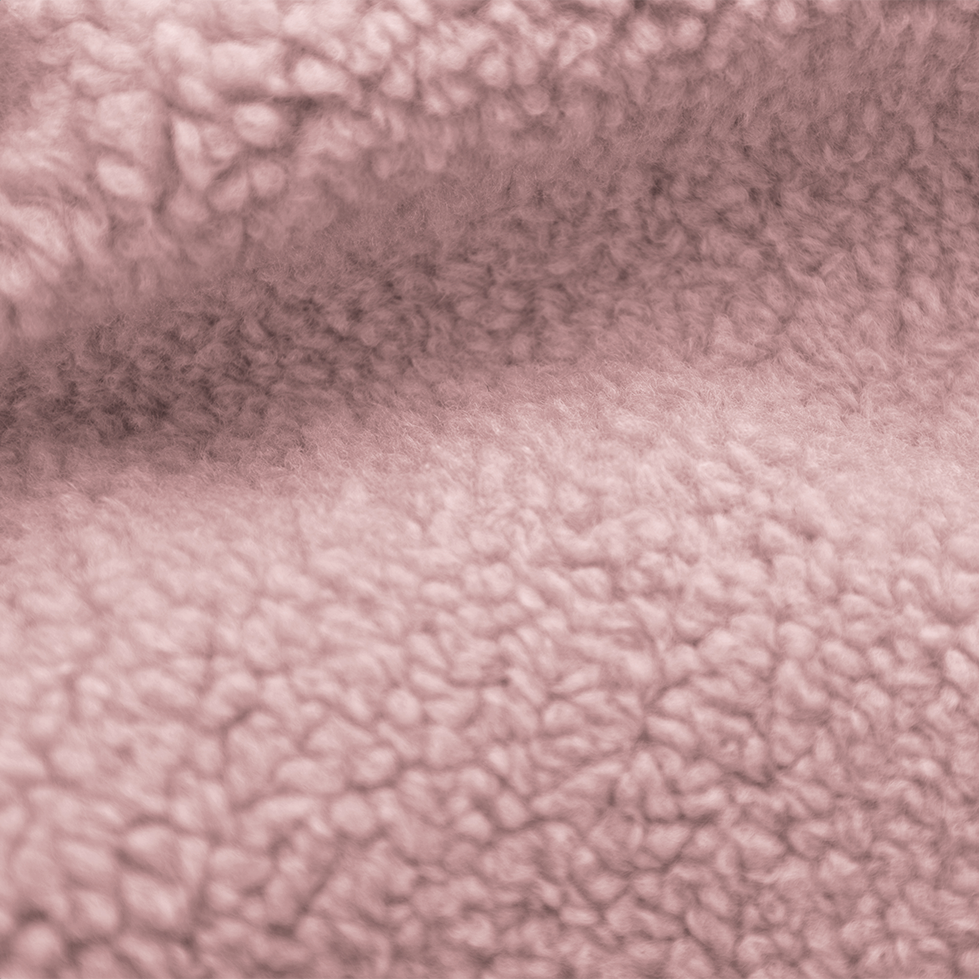 Close-up van zachte, getextureerde stof in een gedempte roze kleur. Het oppervlak lijkt zacht en donzig, lijkend op vacht.