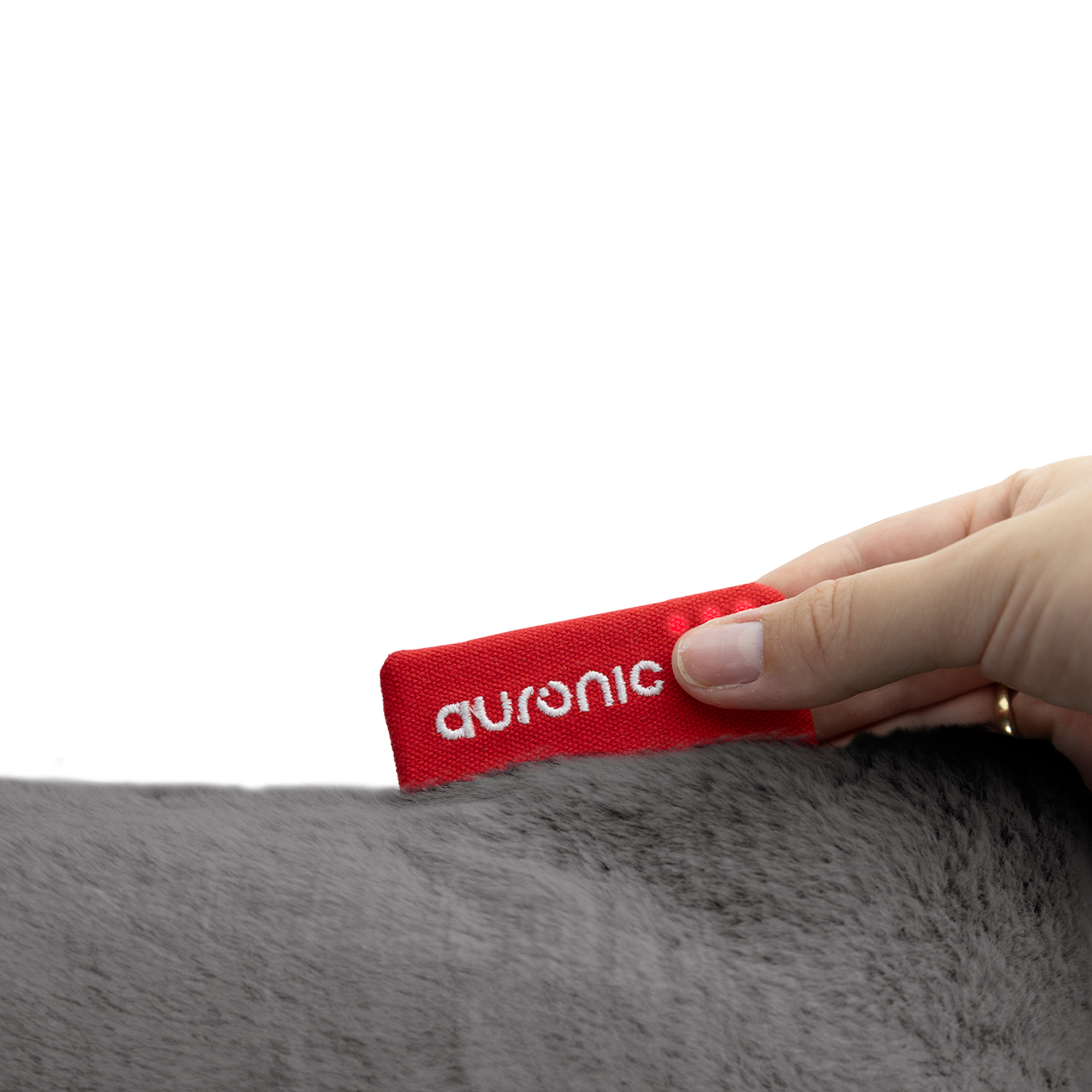 Een hand houdt een rood label met 'auronic' op grijze vacht. Label heeft kleine lampjes. Witte achtergrond.