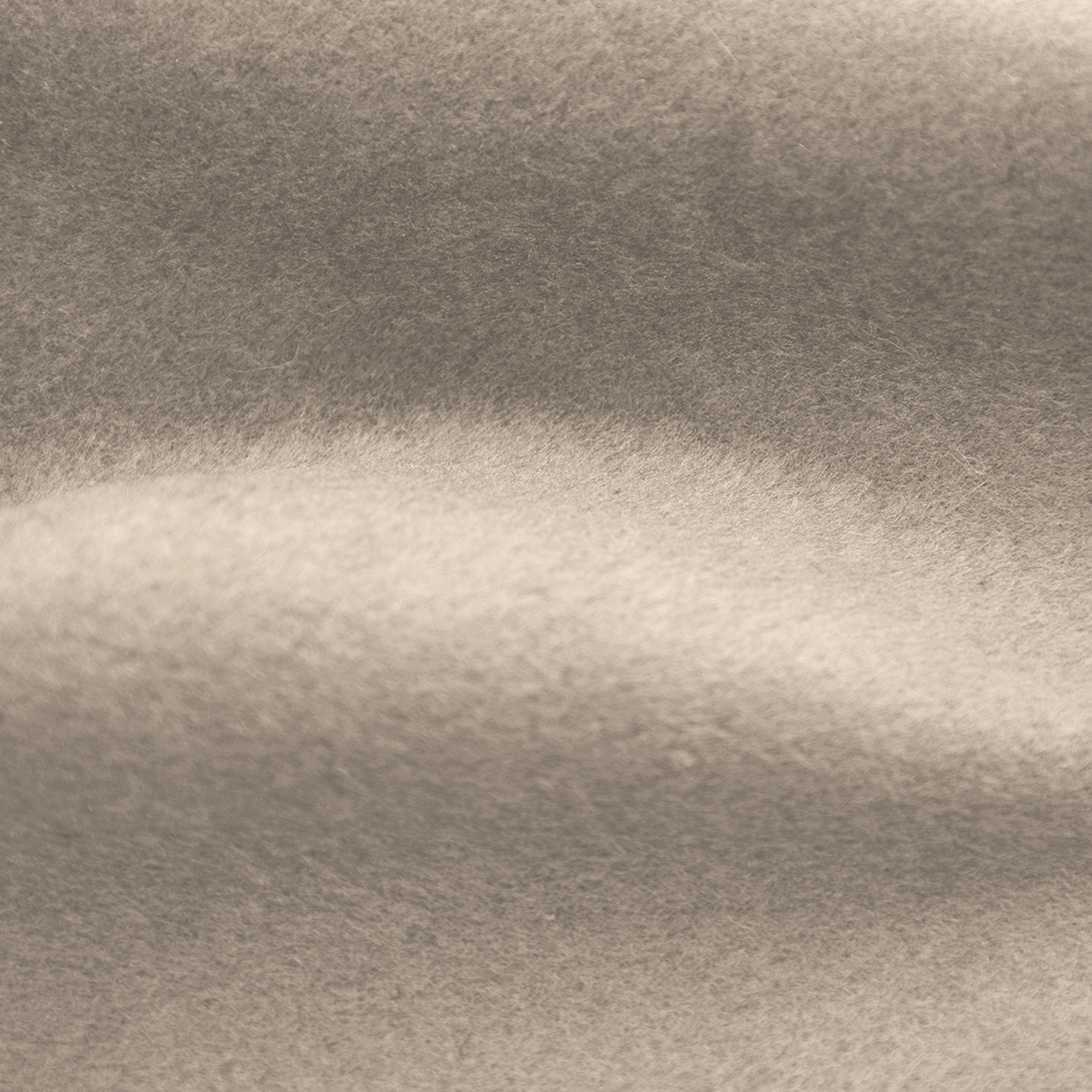 Close-up of a soft, textured fabric. The color is a muted tan, with subtle shadows creating depth.