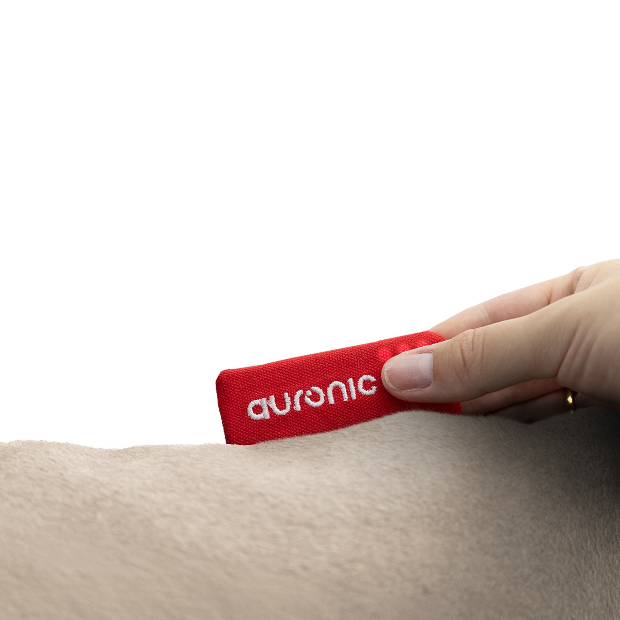 A hand placing a red tag with 'auronic' on a light-colored surface, possibly fur. White background.