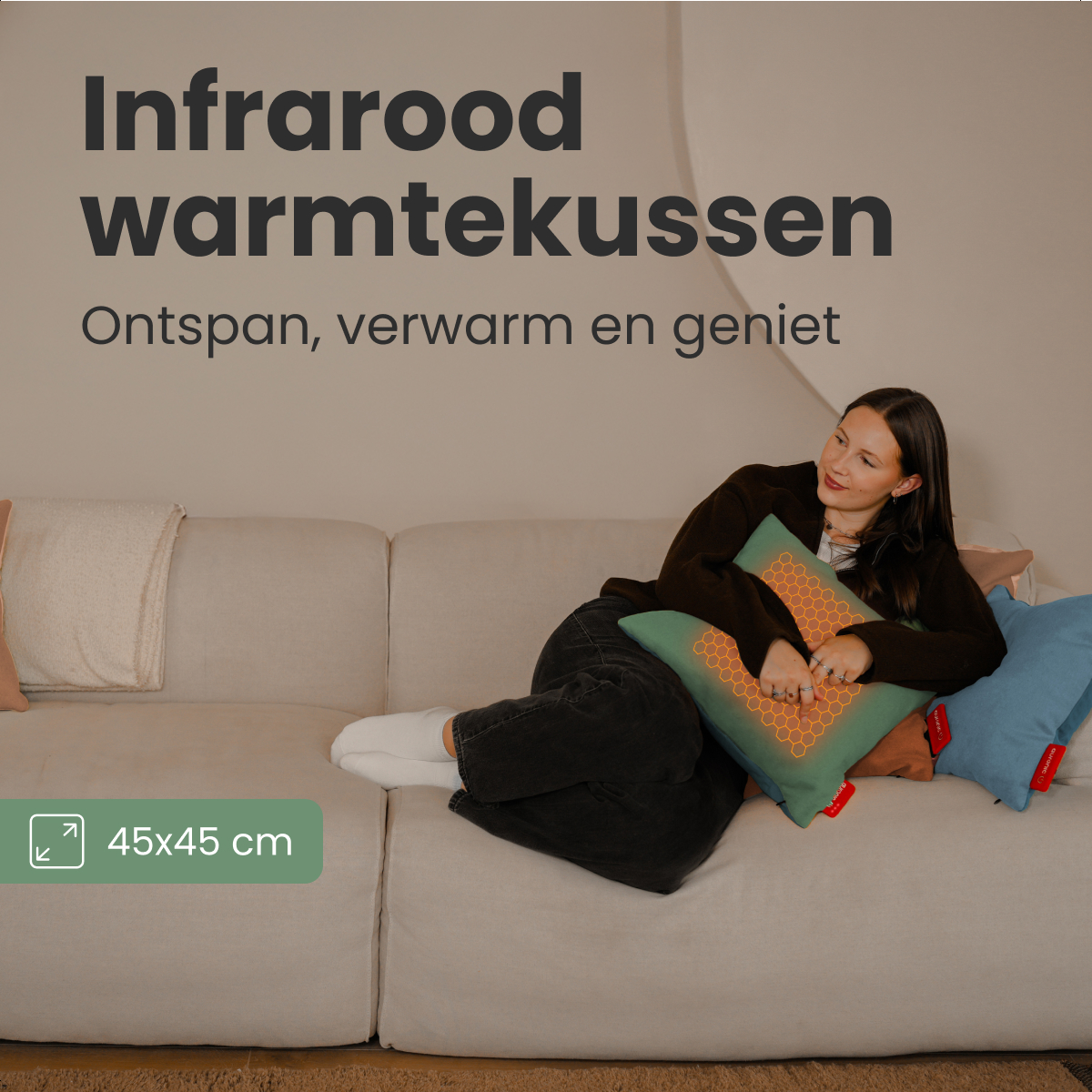 Femme sur canapé avec coussin chauffant vert. Texte : Infrarood warmtekussen. Autres coussins. 45x45 cm dans une boîte verte.
