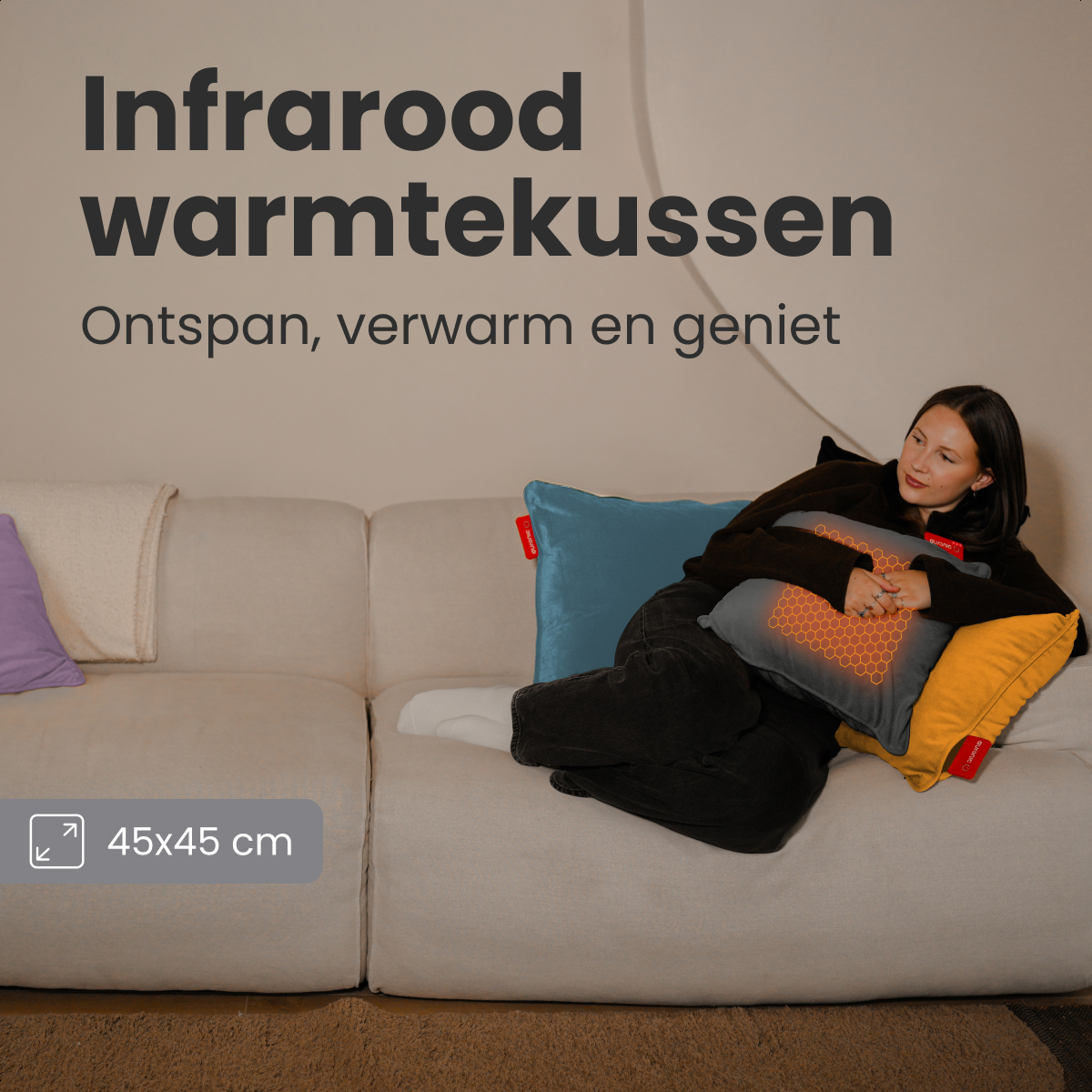 Woman on a couch with heated pillow. Text says 'Infrarood warmtekussen'. Pillows in blue, yellow, and gray. Size 45x45 cm.