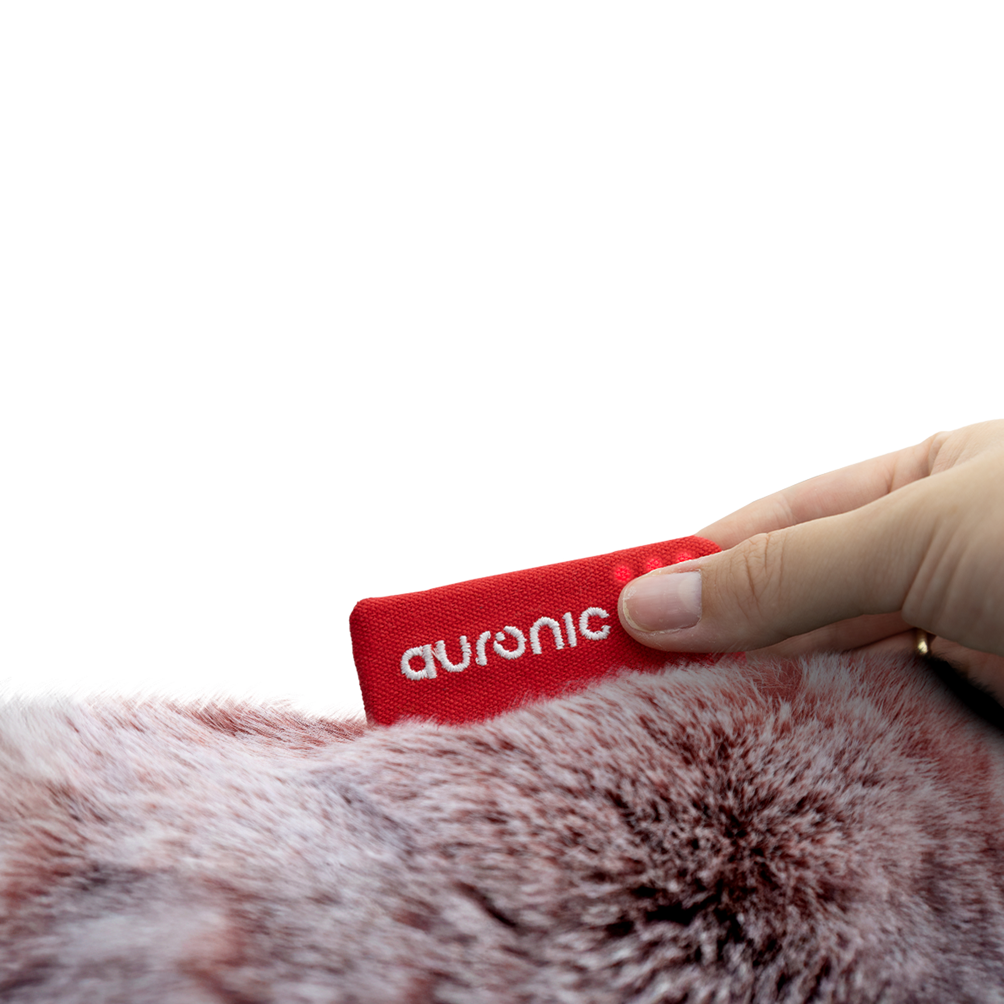 Een hand houdt een rood label met het witte woord 'auronic' op een donzig, rood-wit oppervlak. De achtergrond is wit.