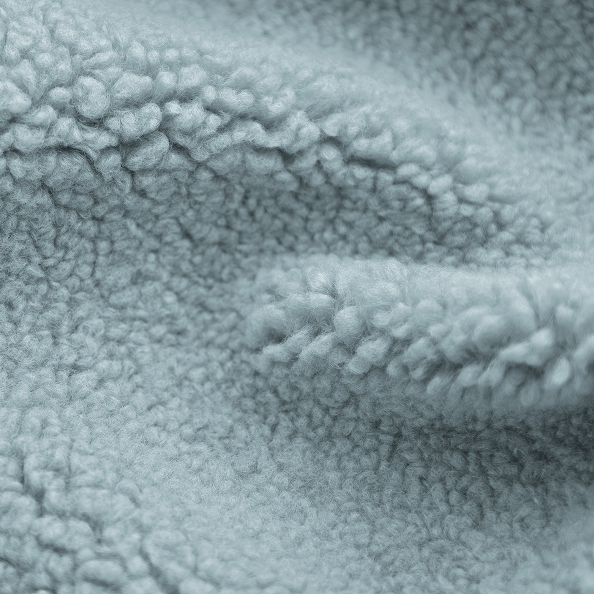 Close-up of soft, light blue fabric. The texture is fluffy and thick, with a dense, uneven surface.