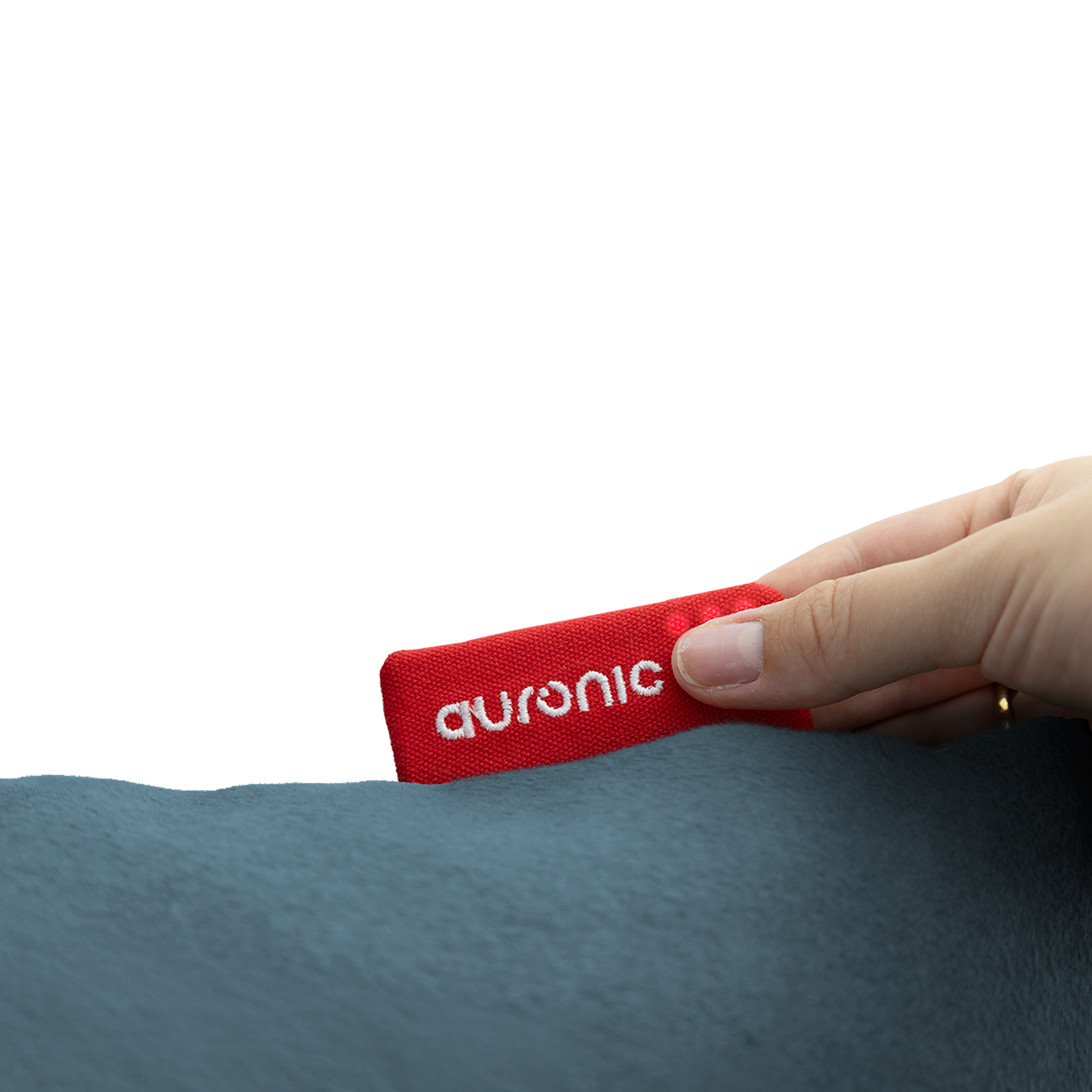 A hand holds a red tag with 'auronic' on it. The tag is over a blue surface, likely fabric. White background.