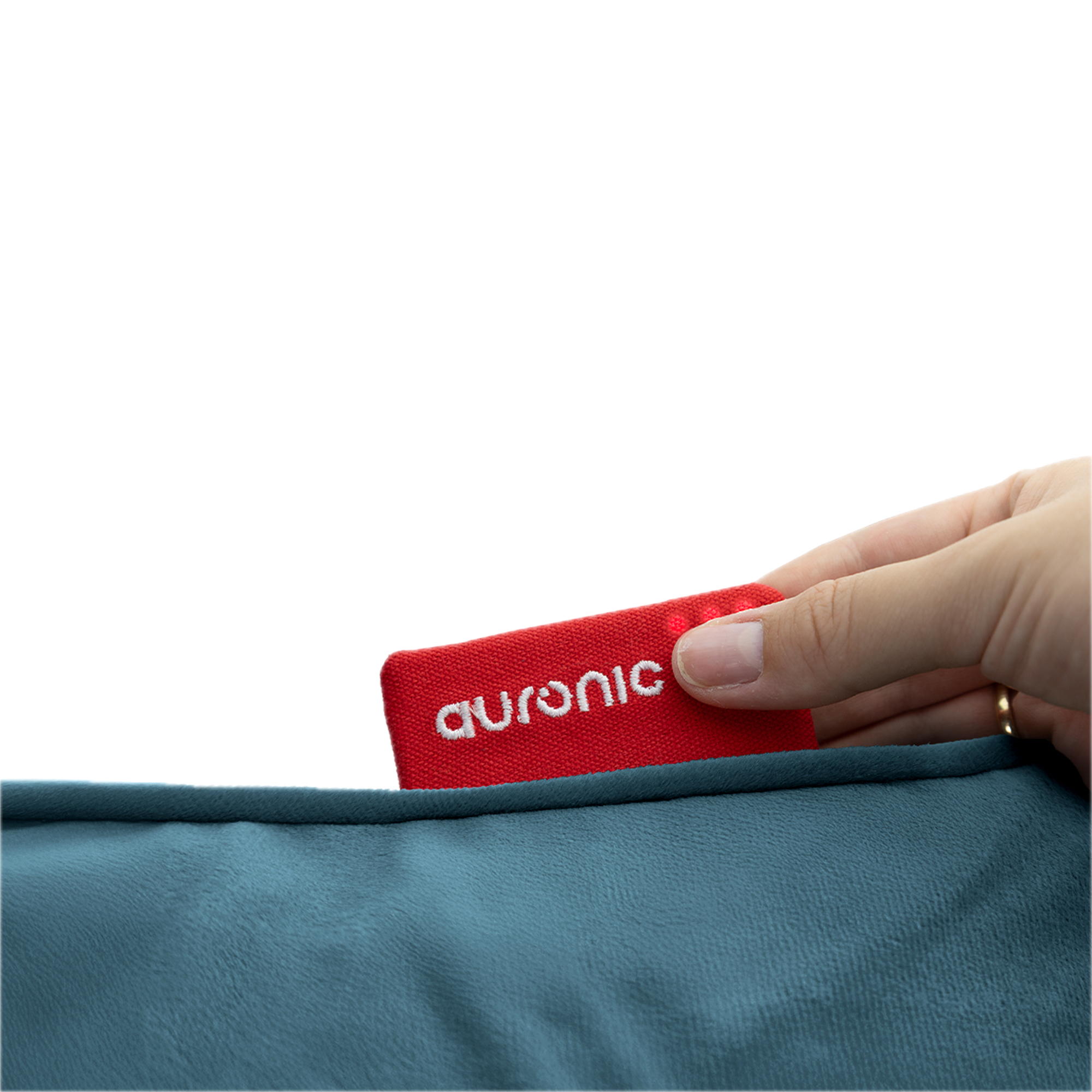 Une main tient une étiquette rouge Auronic, partiellement insérée dans un tissu en peluche bleu-vert. Le fond est blanc.