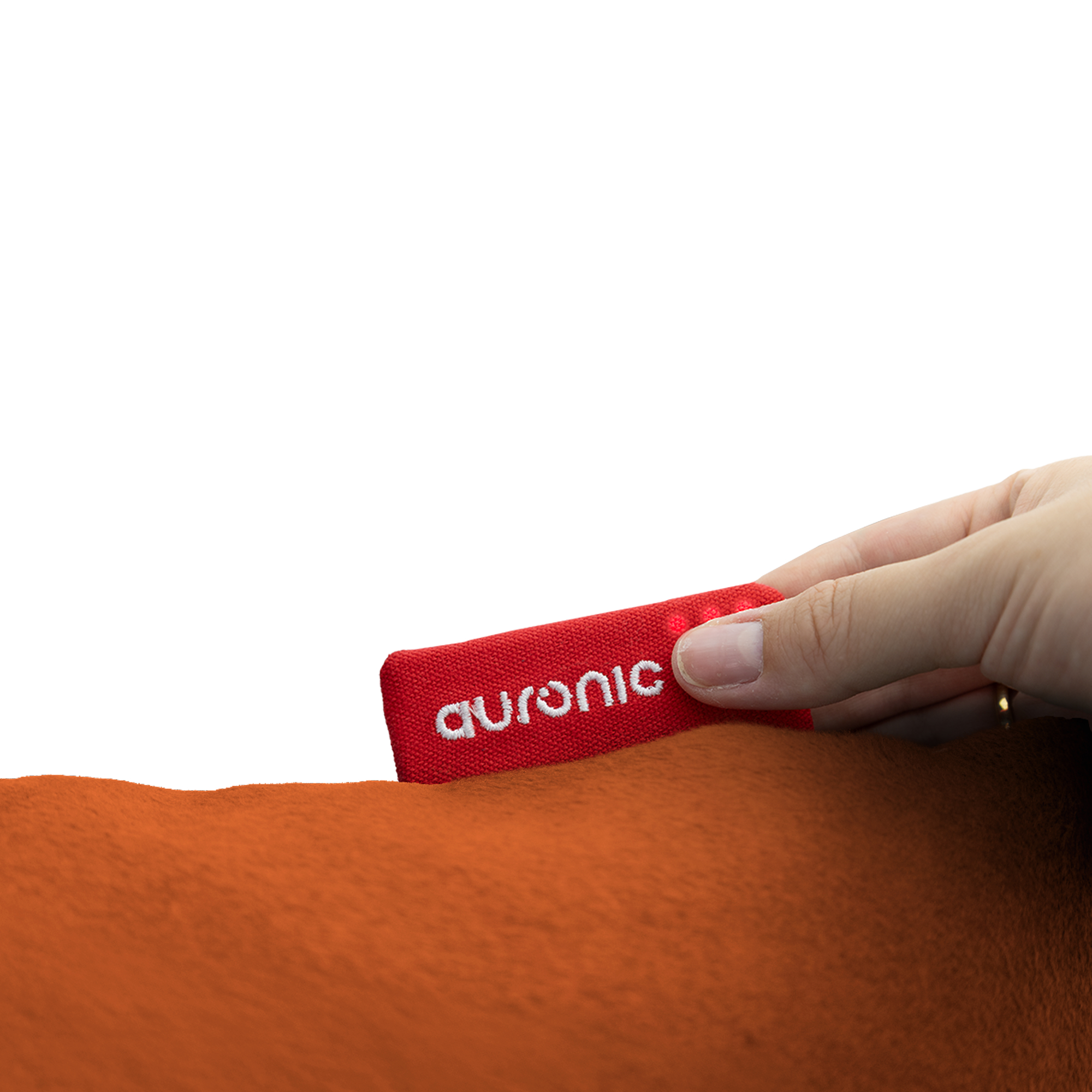 A hand holds a red Auronic tag, placed on orange fabric. White background.