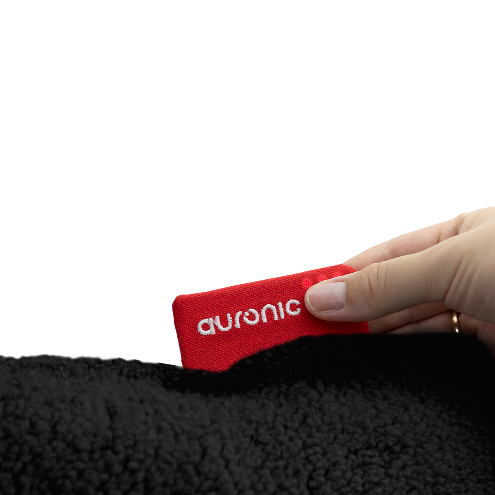 Une main tient une étiquette rouge avec 'auronic', sur une surface noire texturée. Fond blanc.