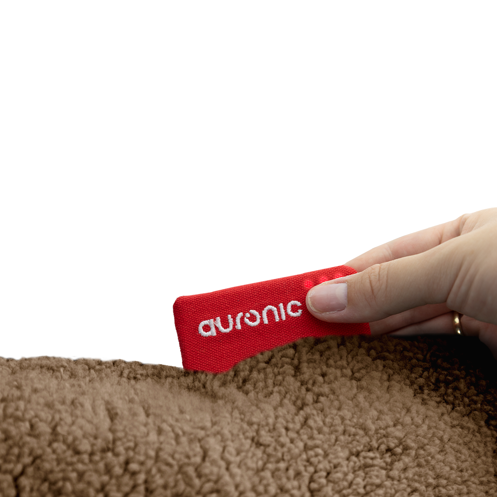Een hand houdt een rood label met 'auronic' vast, in de buurt van een bruin, getextureerd oppervlak.