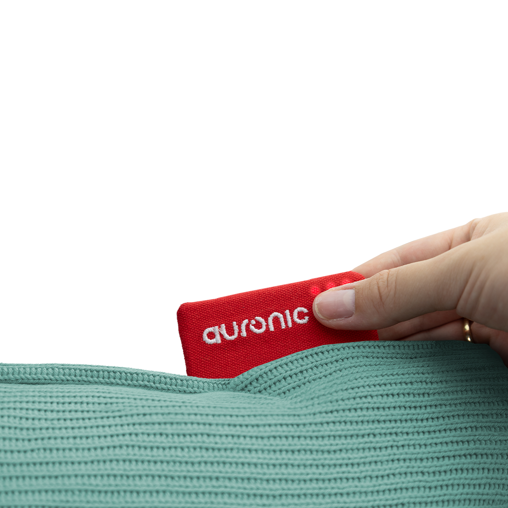 Een hand trekt een rood label met 'auronic' uit een groene gebreide stof. Witte achtergrond.