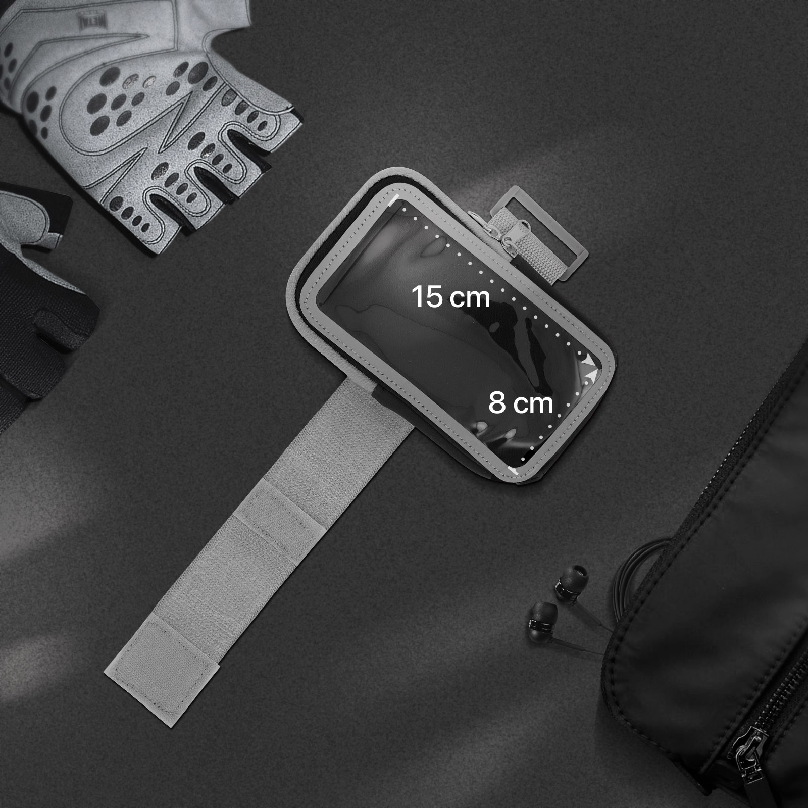 Un support de téléphone de bras, des gants et un sac sont sur une surface. Dimensions du support 15 cm x 8 cm.