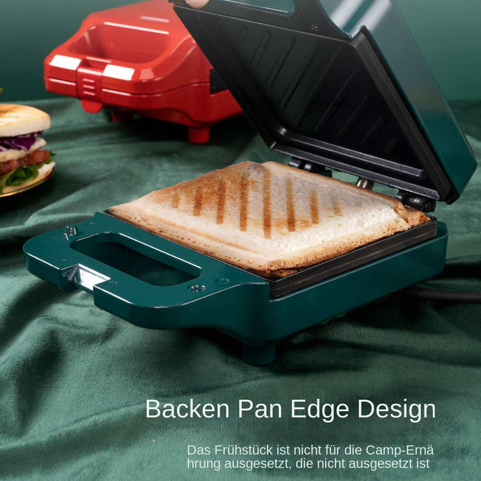 Ein grüner Sandwichmaker mit einem getoasteten Sandwich darin. Im Hintergrund ist ein roter. Links ist ein Sandwich.