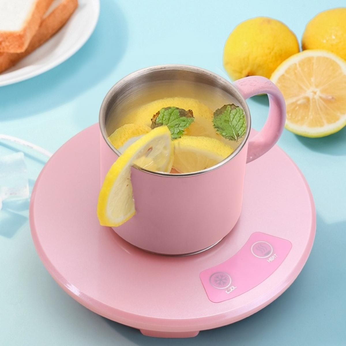 Rosa Tasse mit Zitronenscheiben und Minze auf einem rosa Wärmer. Zitronen und Brot im Hintergrund auf blauem Untergrund.