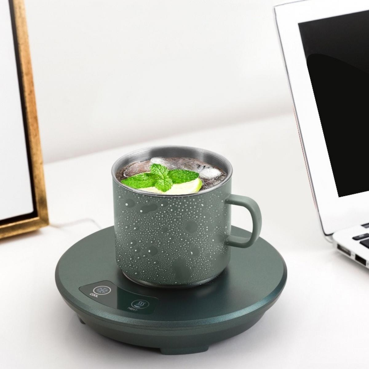 Ein grüner Becher mit Eis, Minze und Zitrone steht auf einem Wärmer. Ein Laptop und ein gerahmtes Bild befinden sich im Hintergrund.