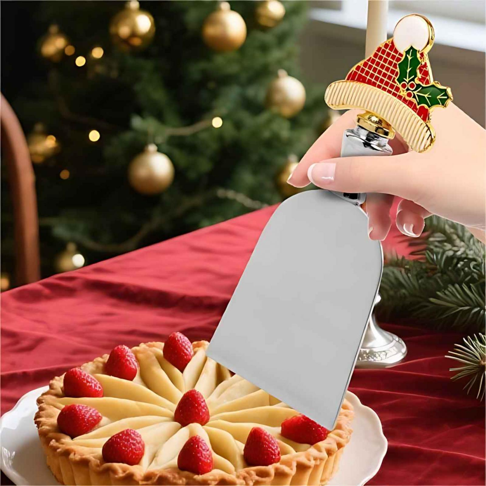 Hand hält Tortenheber in der Nähe von Erdbeertorte. Weihnachtsbaum im Hintergrund. Festliche Szene.
