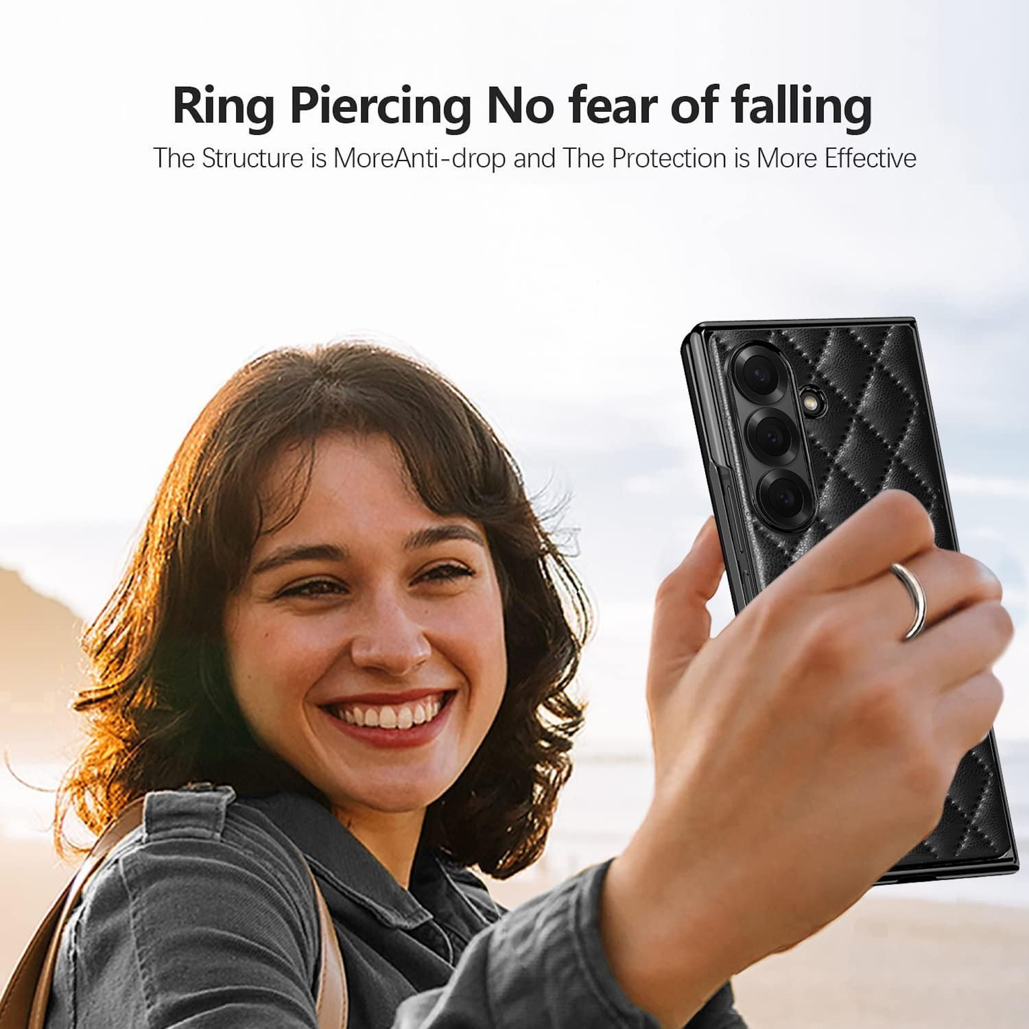 Una mujer sonríe, sosteniendo una funda de teléfono negra. Un anillo en su dedo. El fondo es una playa con el texto: Ring Piercing No fear of falling.
